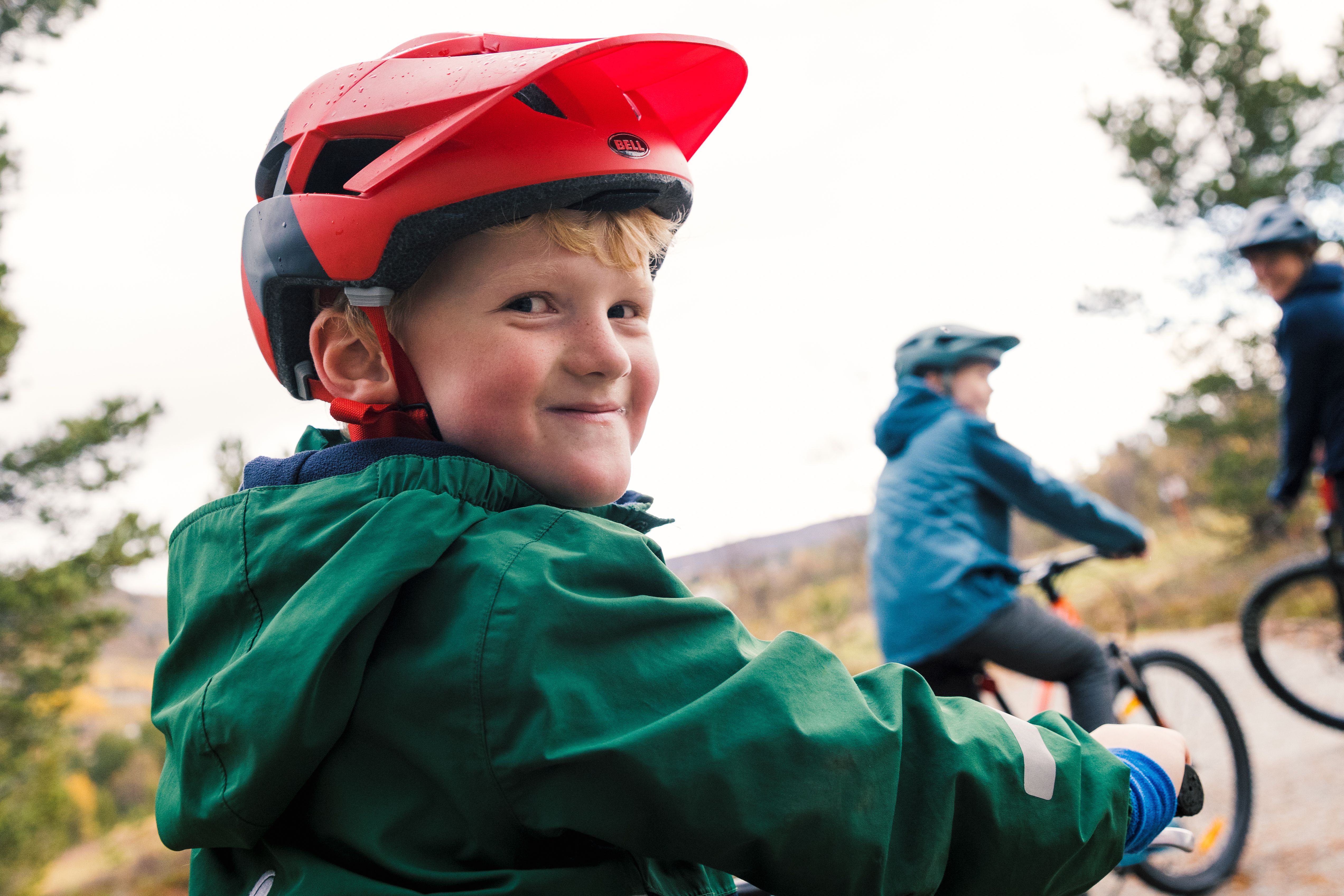 Young boy smiling while biking with his family in Geilo.