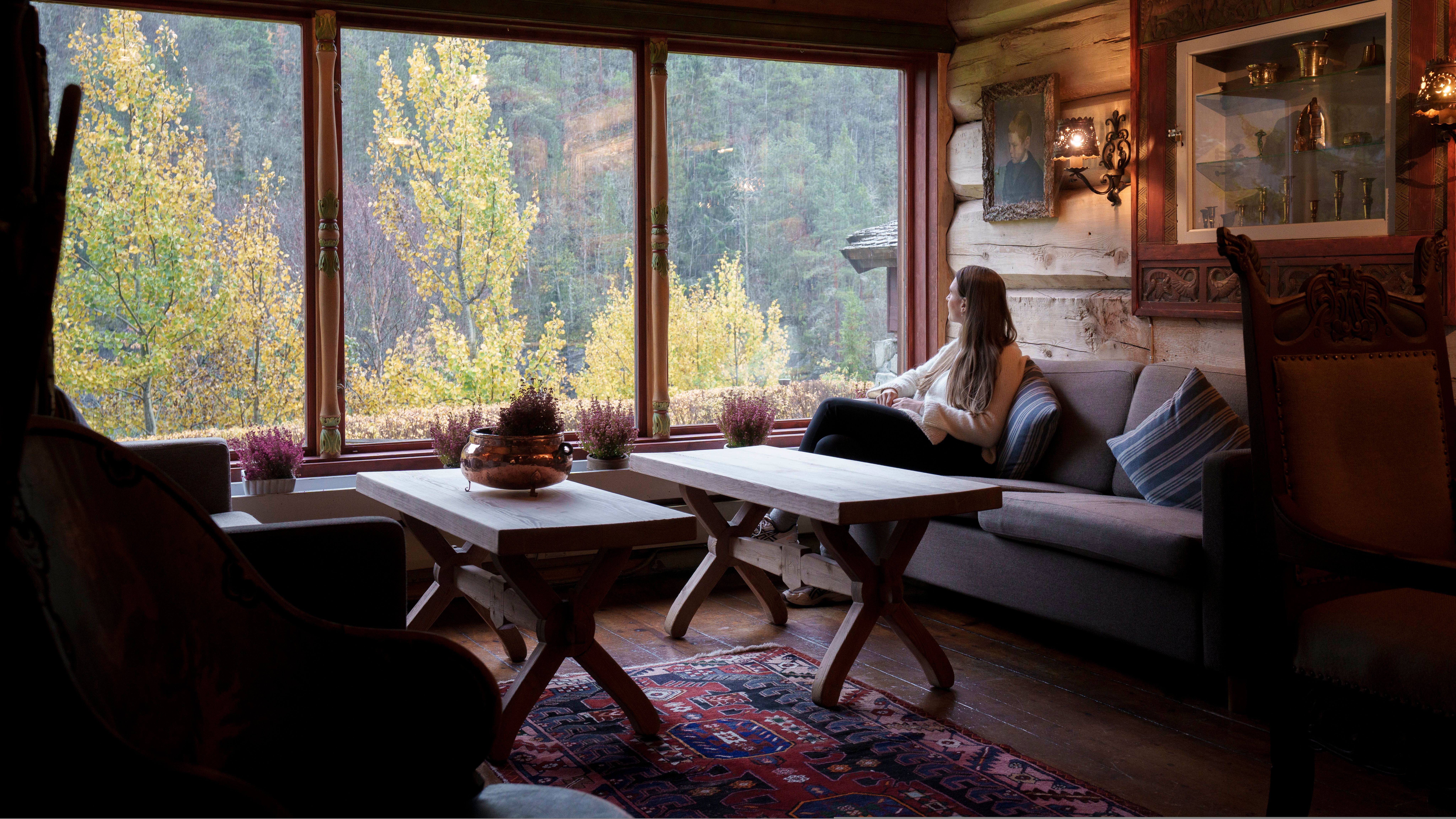A woman looking out the window in a historic hotel.