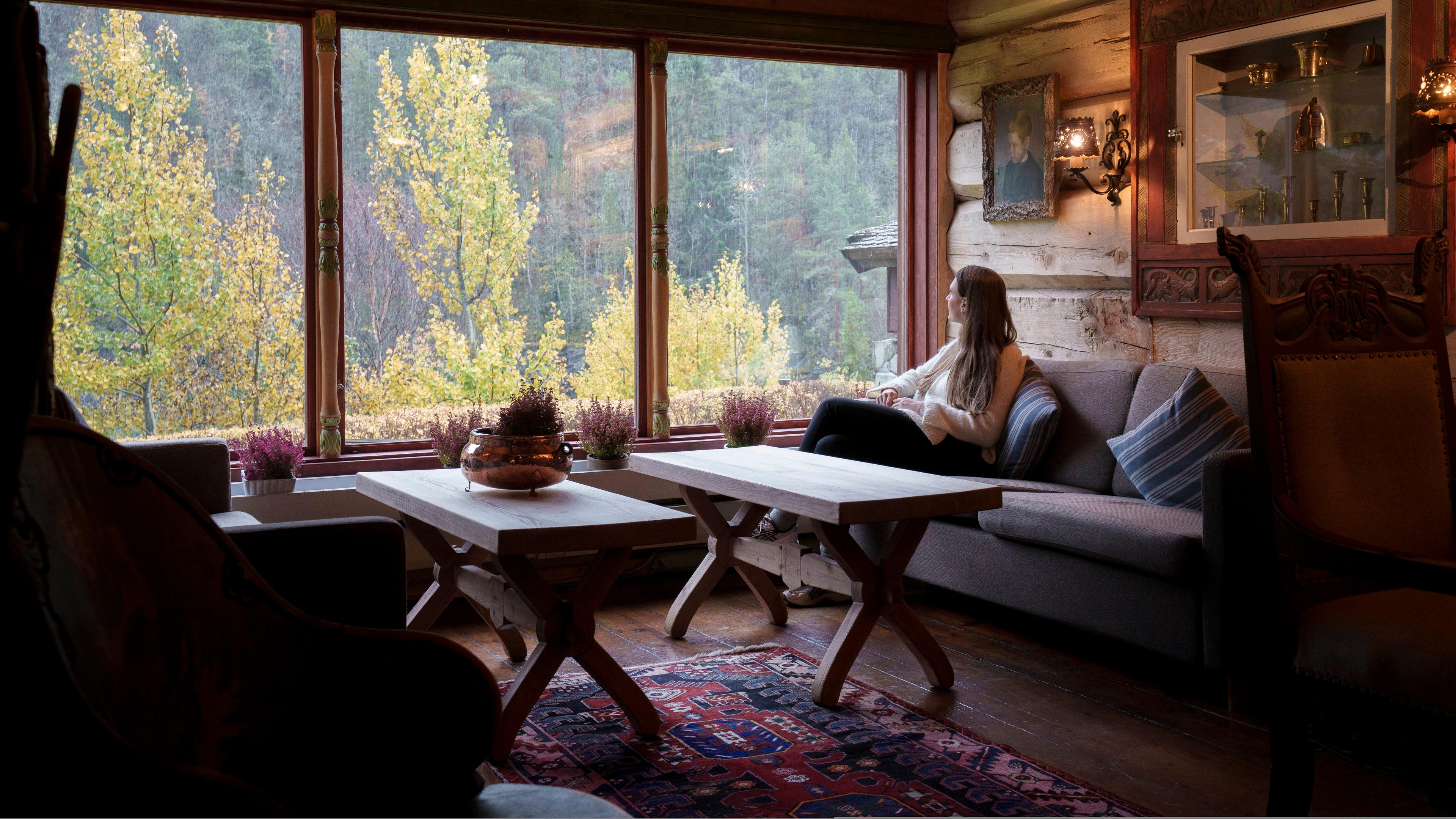 A woman looking out the window in a historic hotel.