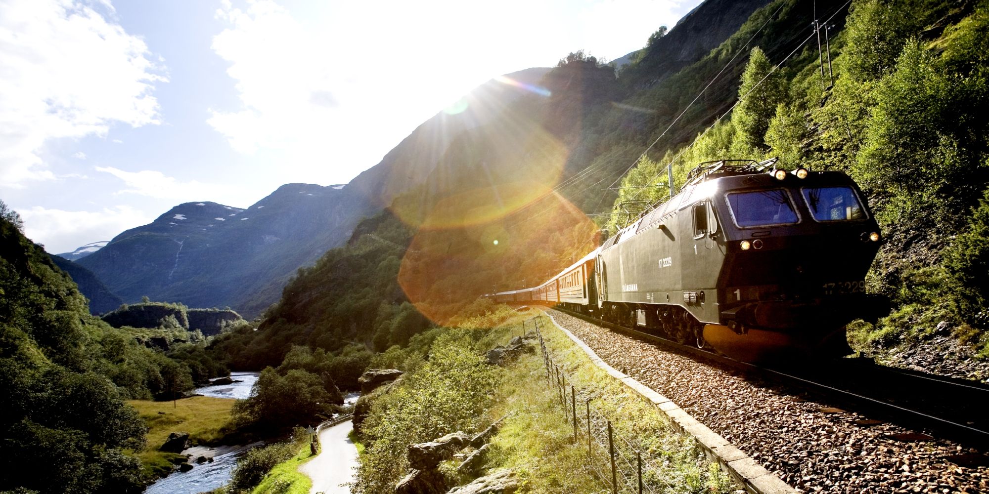 A train passing through a scenic valley in Flåm