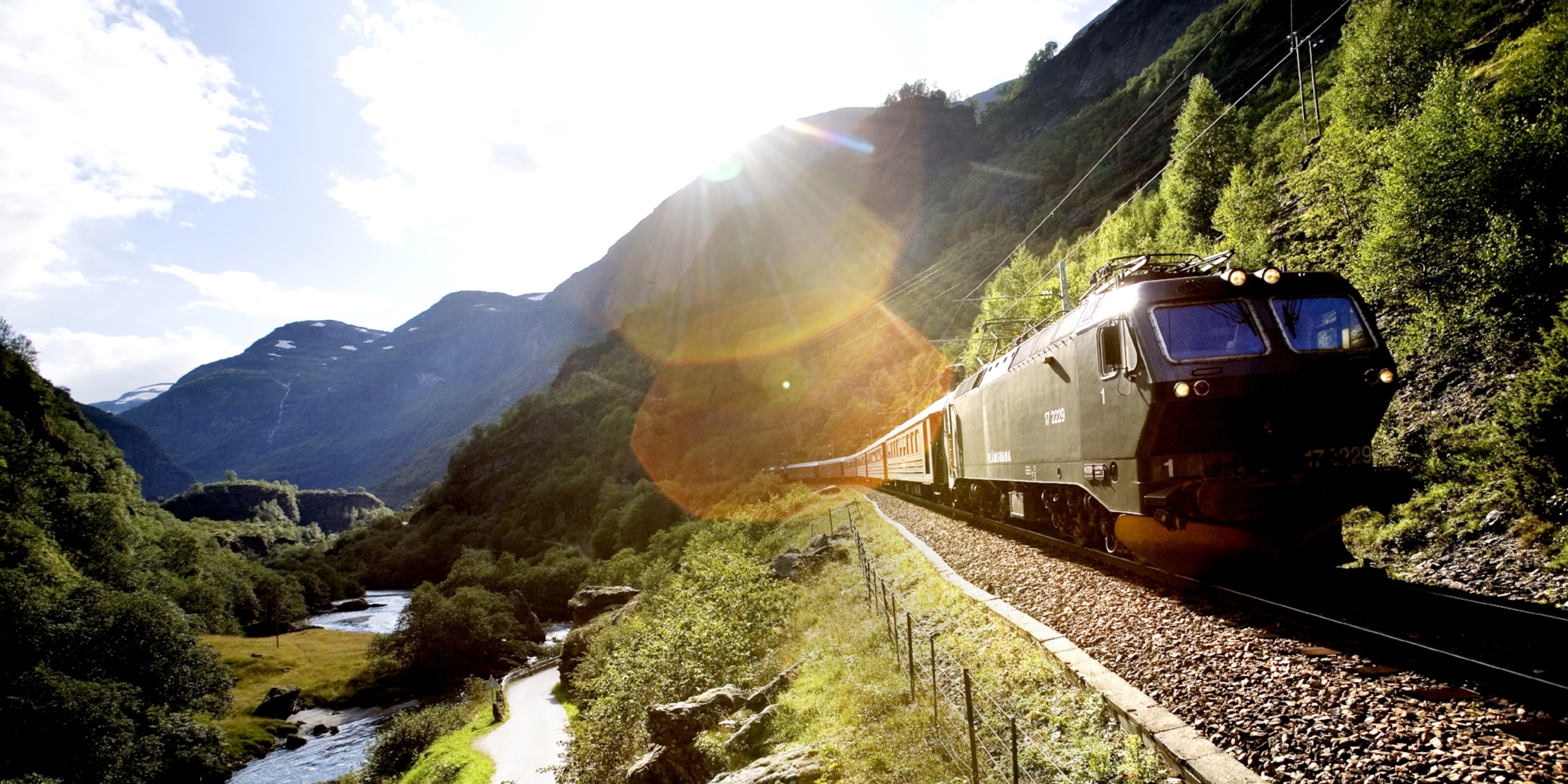 A train passing through a scenic valley in Flåm