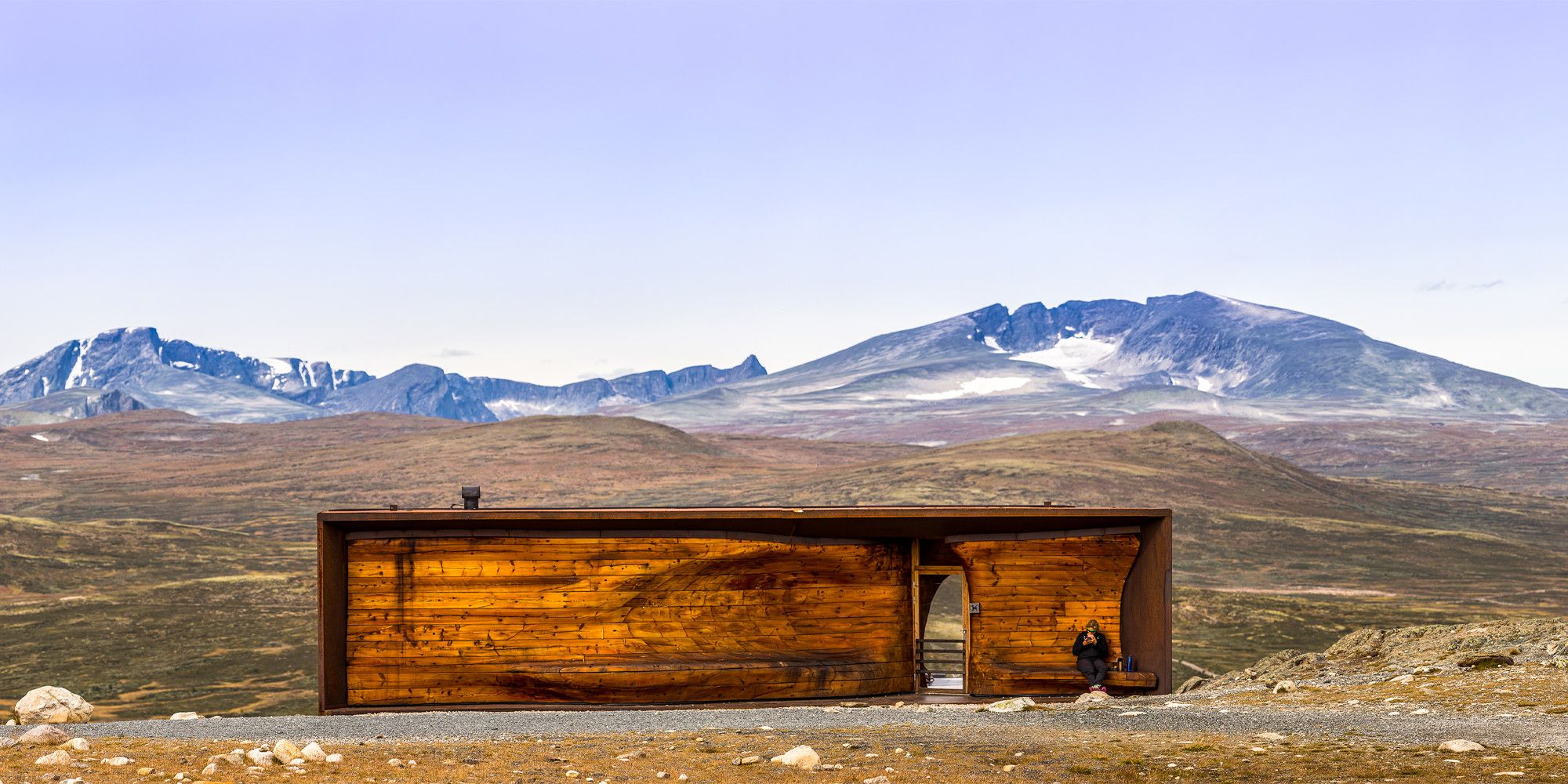 A person at Viewpoint Snøhetta with the mountain Snøhetta in the background. Dovrefjell, Eastern Norway