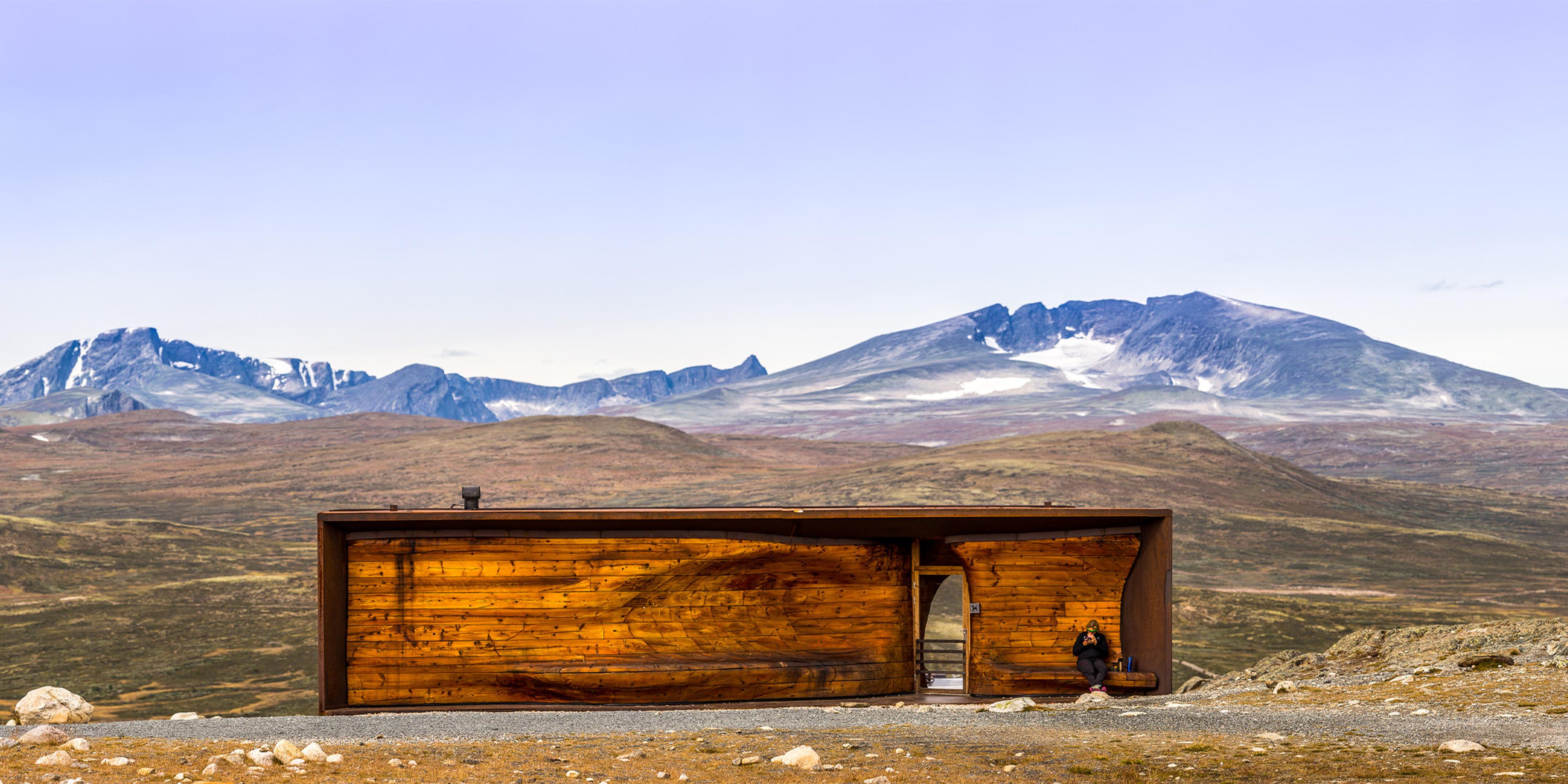 En person sidder i Viewpoint Snøhetta i Dovrefjell Nationalpark, Norge