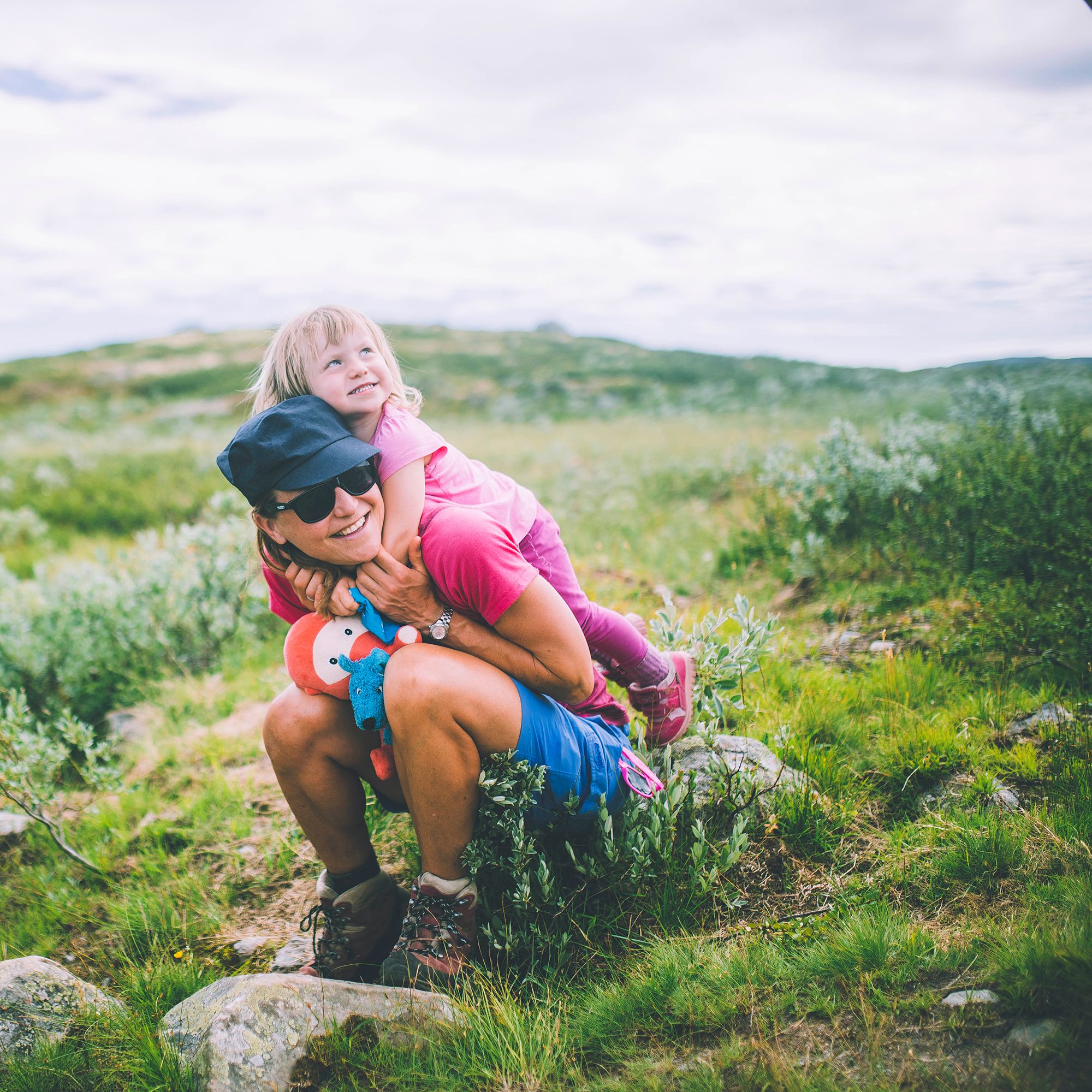 Mother sitting with her daughter on her back in Hardangervidda national park in Norway