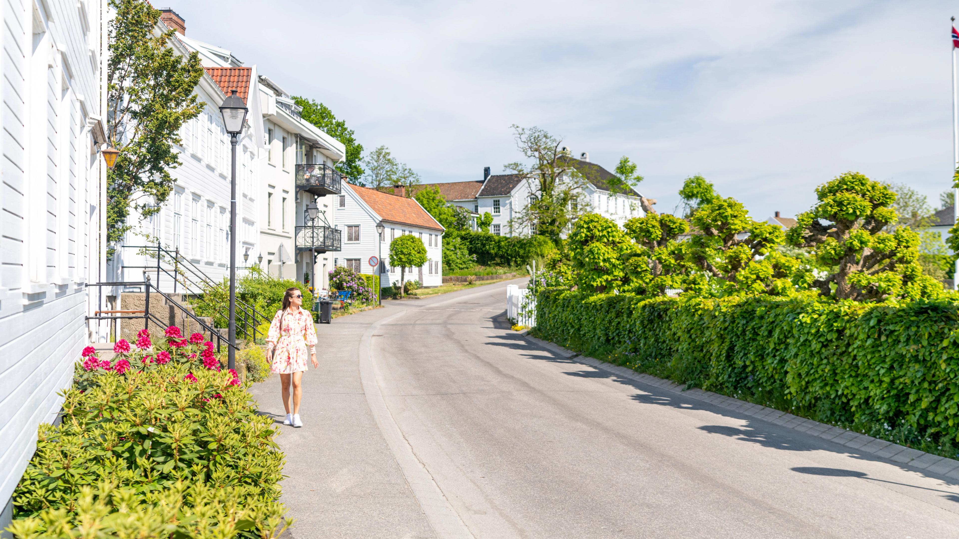 Girl walking in street by the ocean front in Lillesand, Southern Norway