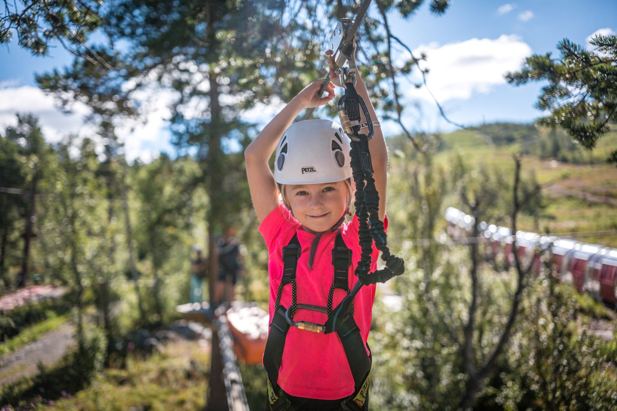 A young girl balancing between treetops in the high-rope course in Geilo sommerpark, Eastern Norway