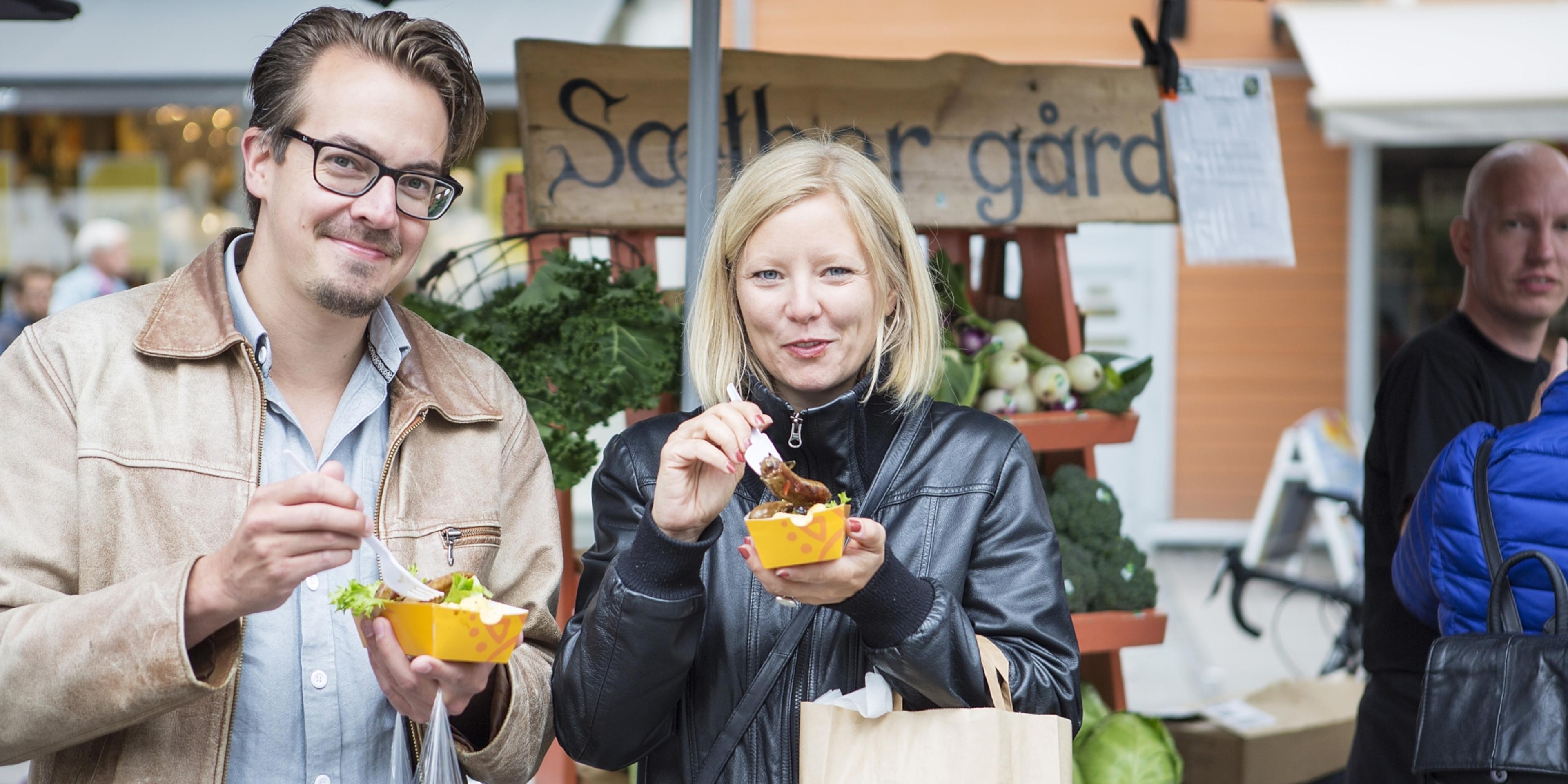 Man and woman eating food at festival in Trondheim