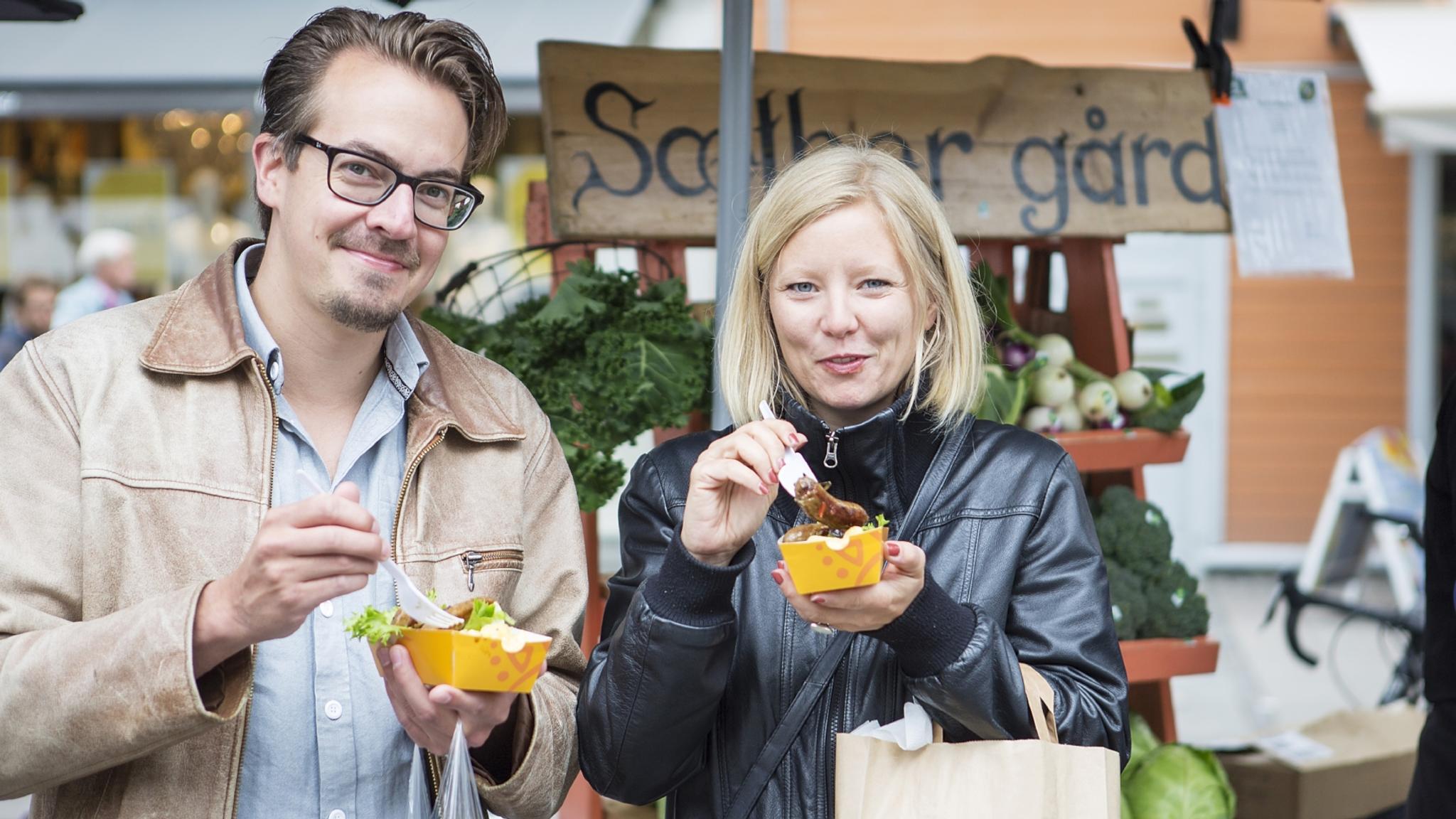 Man and woman eating food at festival in Trondheim