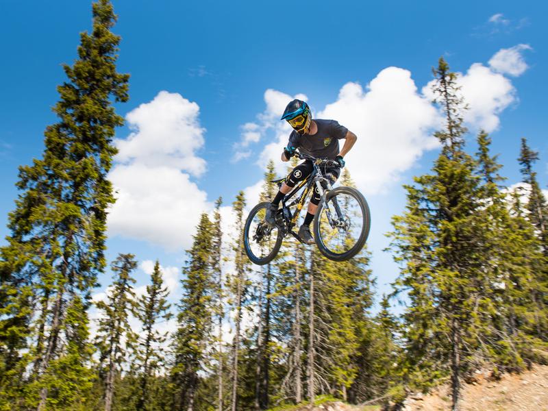 Iemand die met een mountainbike een sprong maakt in Hafjell bike park, Oost-Noorwegen
