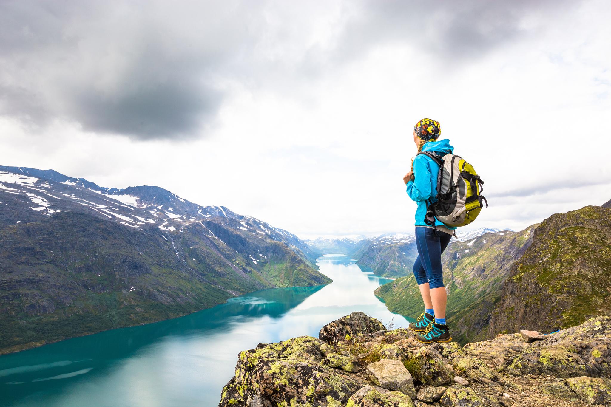 En kvinde nyder udsigten over Gjendesøen fra Besseggen i Jotunheimen, Norge