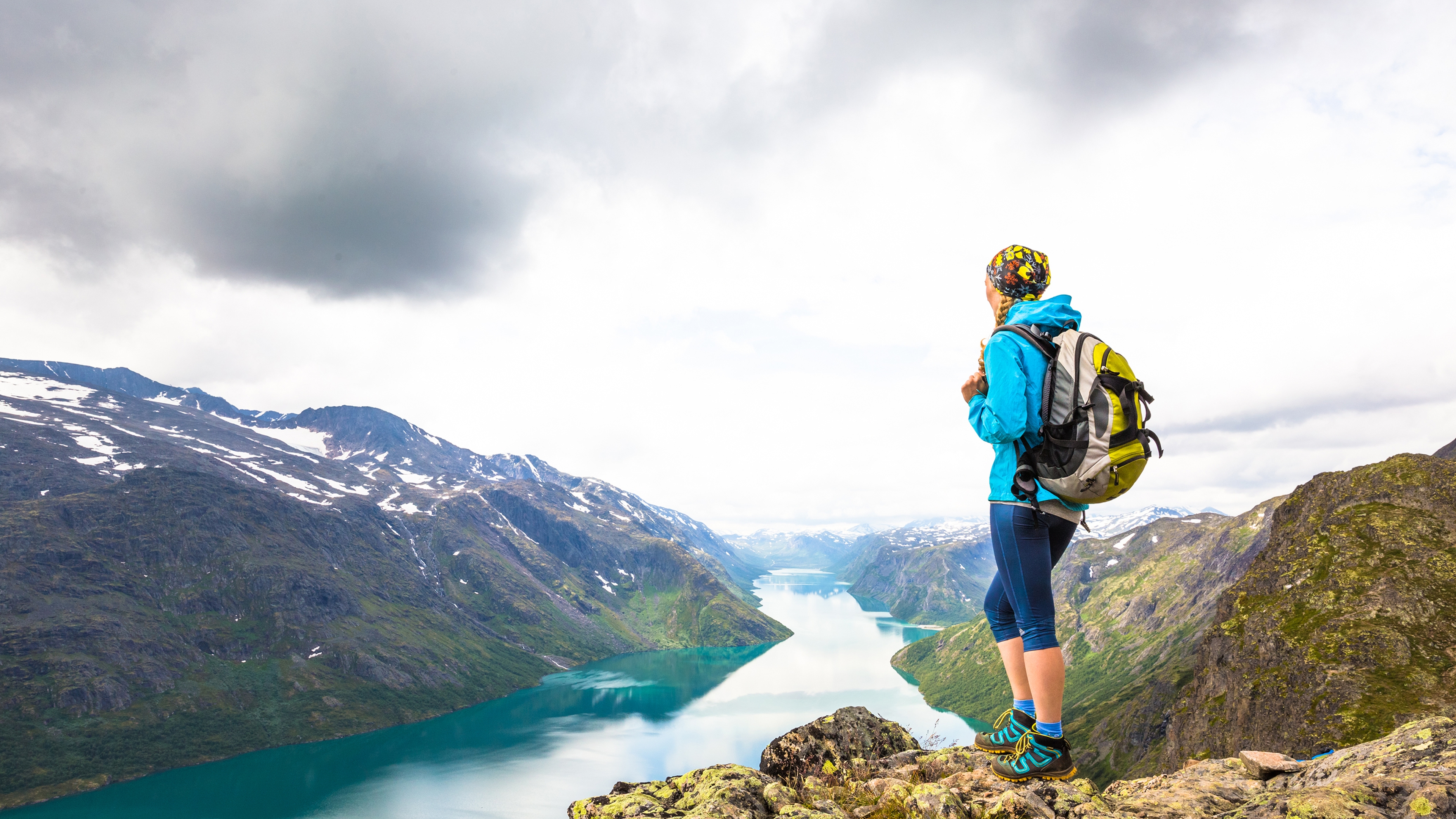 Eine Frau blickt über den See Gjende in den Jotunheimen Bergen in Ostnorwegen