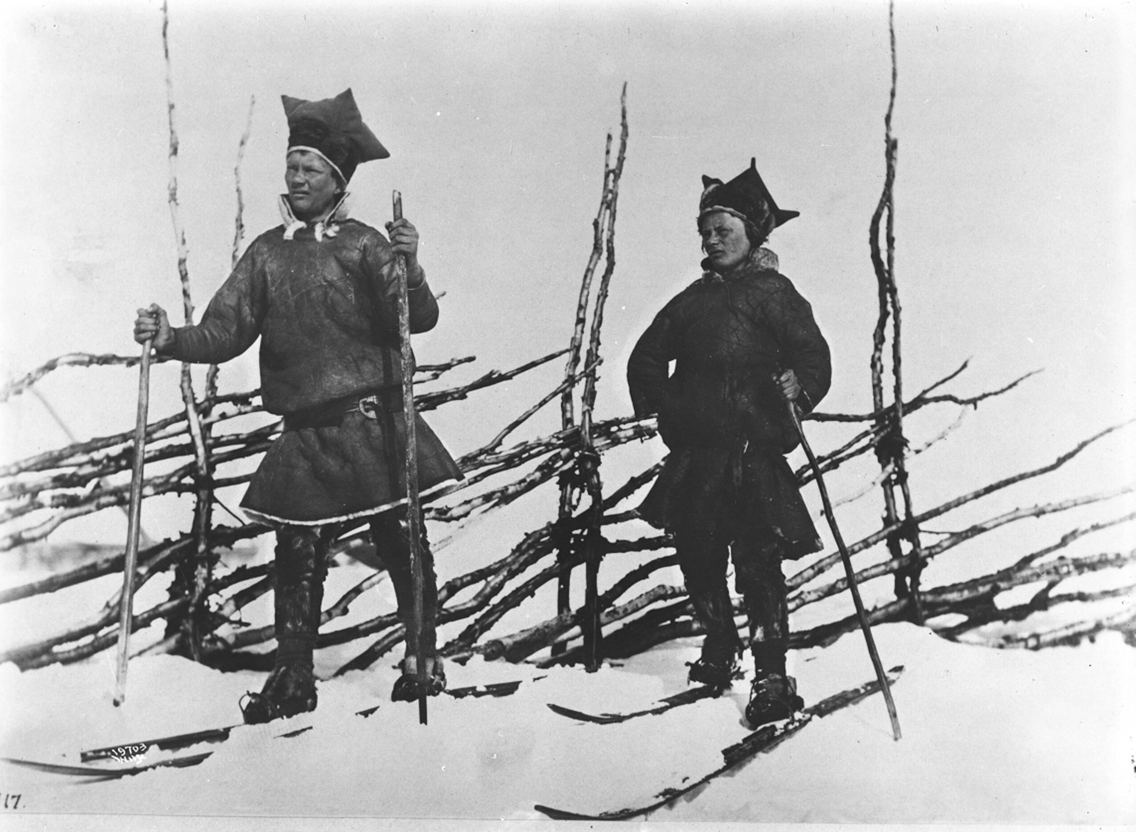 Two people in Sami costumes skiing, 1882