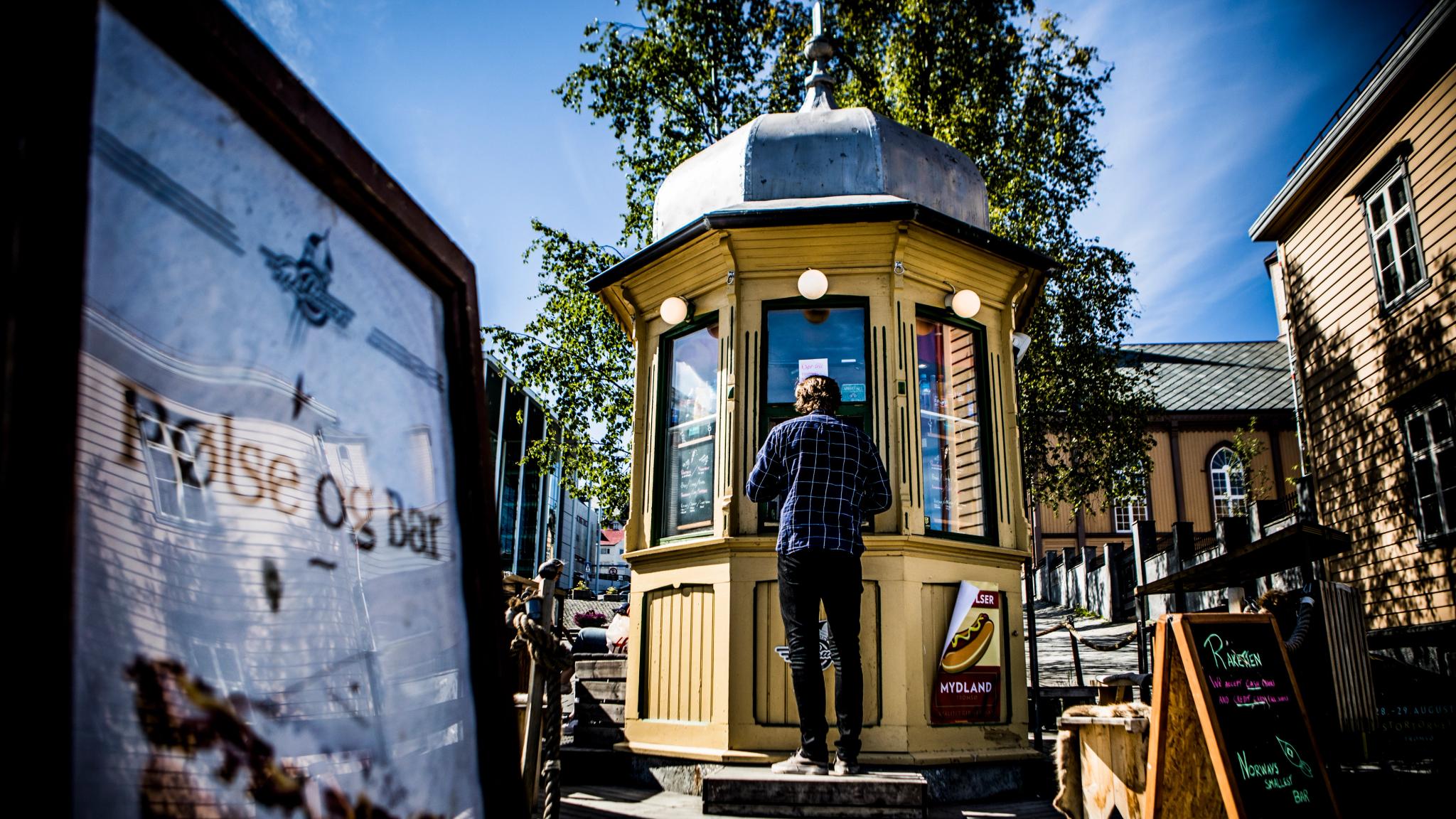 A man ordering a hot dog at the legendary kiosk Raketten Bar & Pølse in Tromsø in Northern Norway