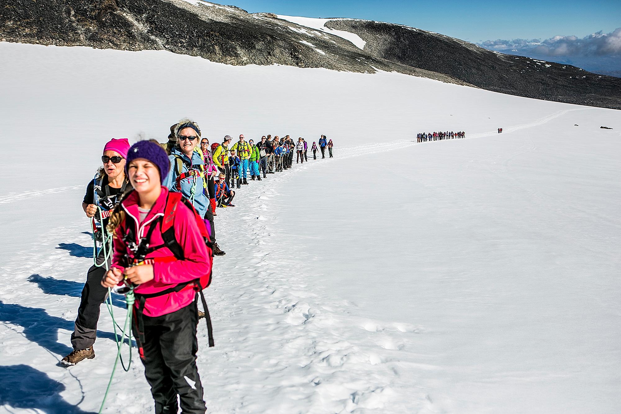 A large group of people strapped together on their way to Galdhøpiggen in Jotunheimen