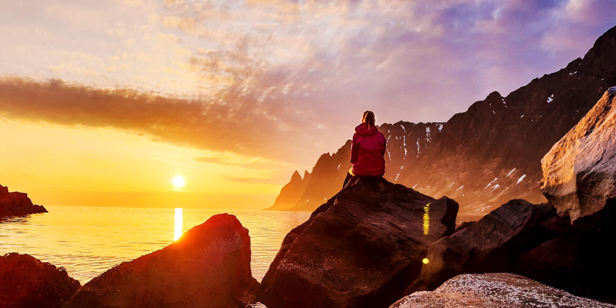 Una persona observa el sol de medianoche desde la isla de Senja, en el Norte de Noruega.