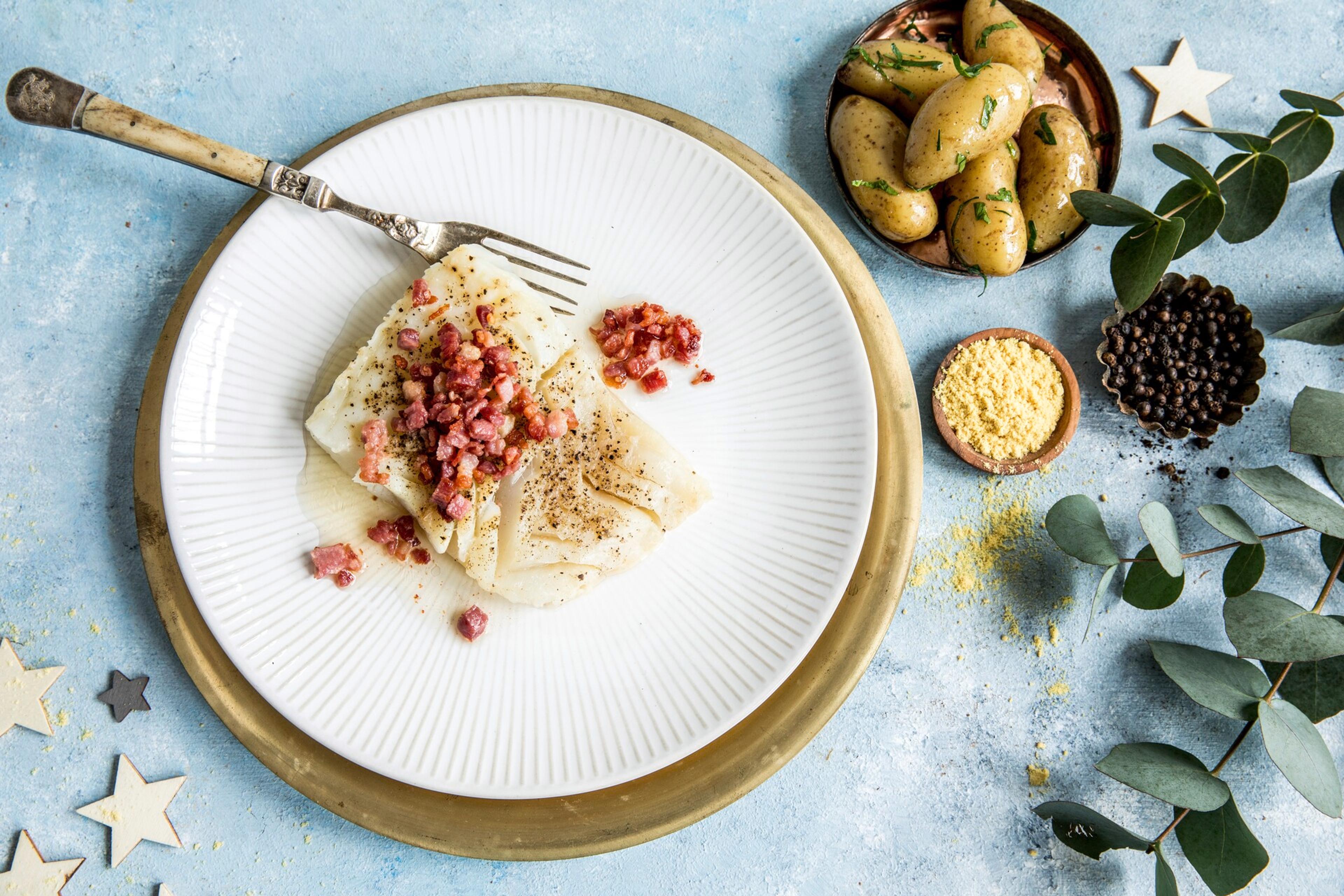 A plate with lutefisk, bacon and potatos