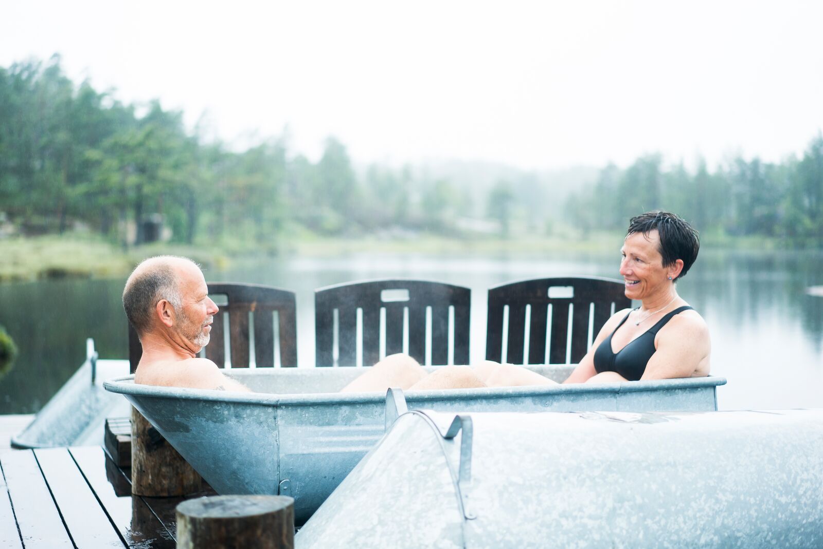 Two people relaxing in a bath tube at Canvas Hotel's spa, Norway.
