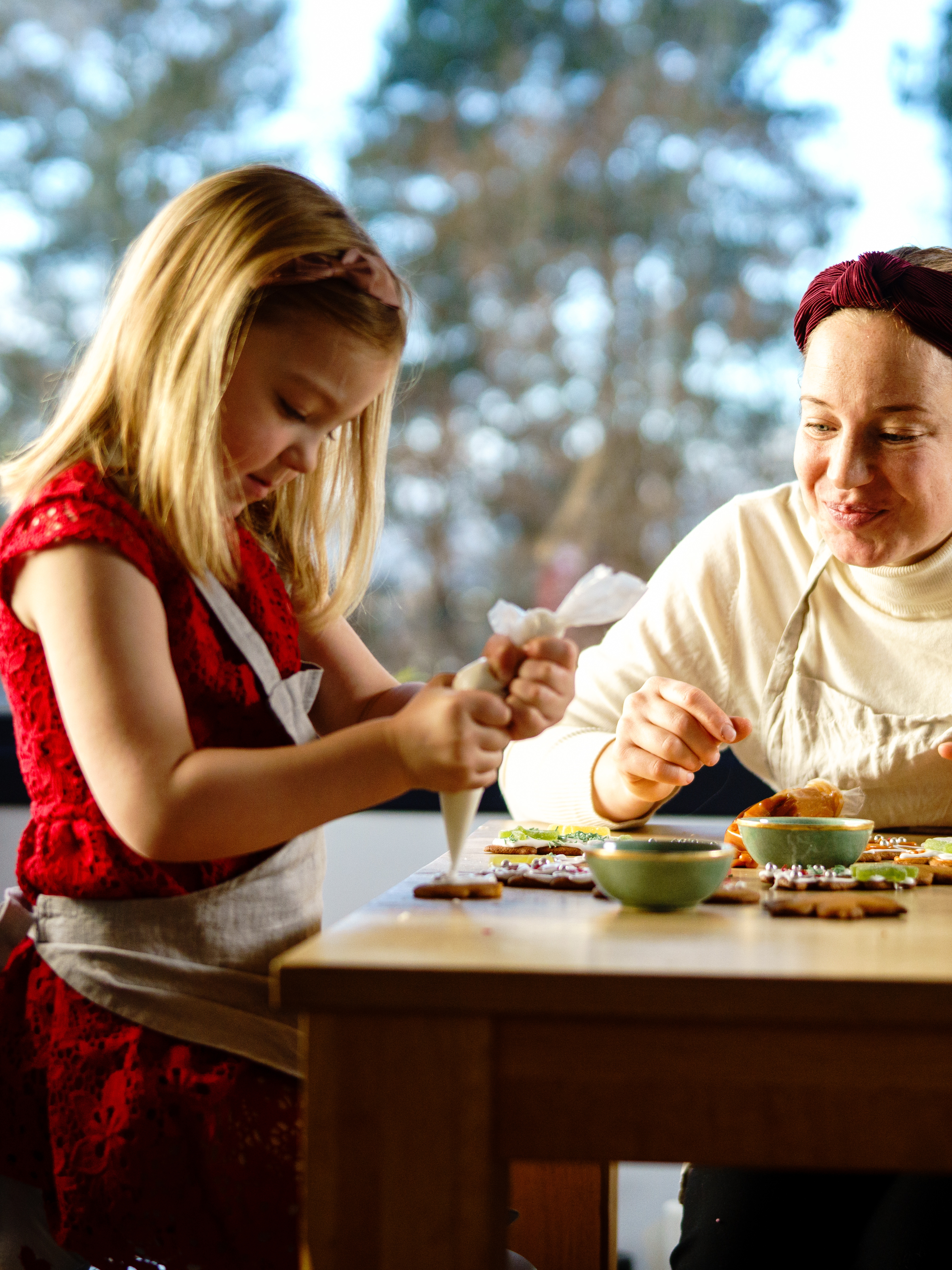 Mother and daughter decorating gingerbread together