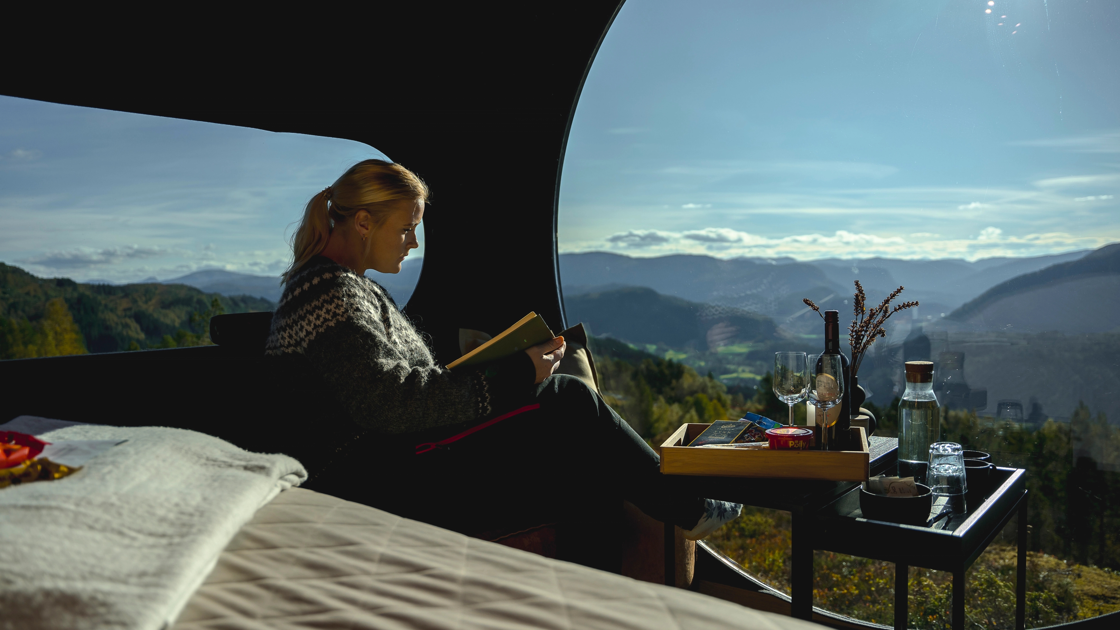 Woman reading a book inside Birdbox Langeland