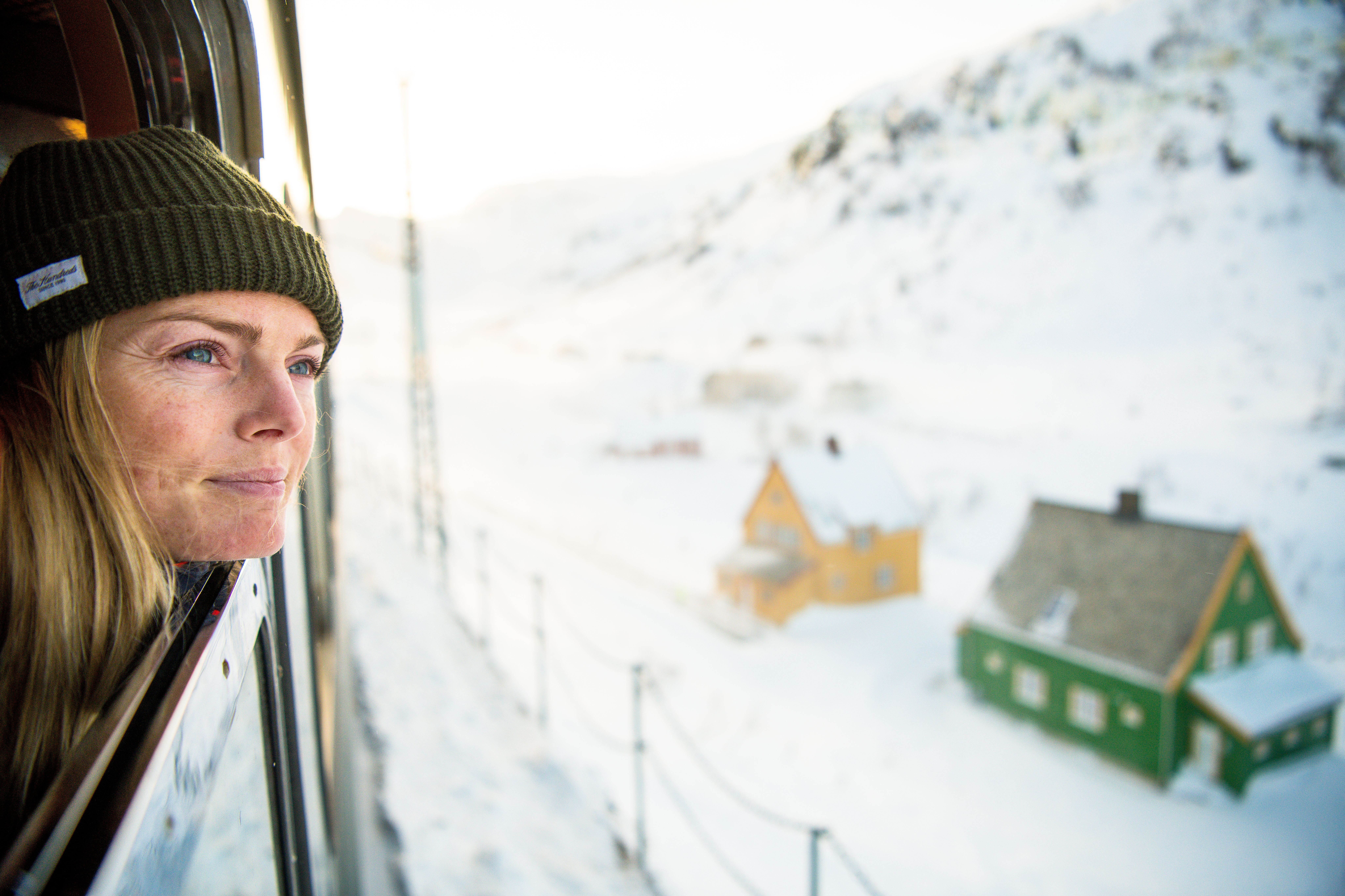 A woman looking out of the train along Flåmsbana