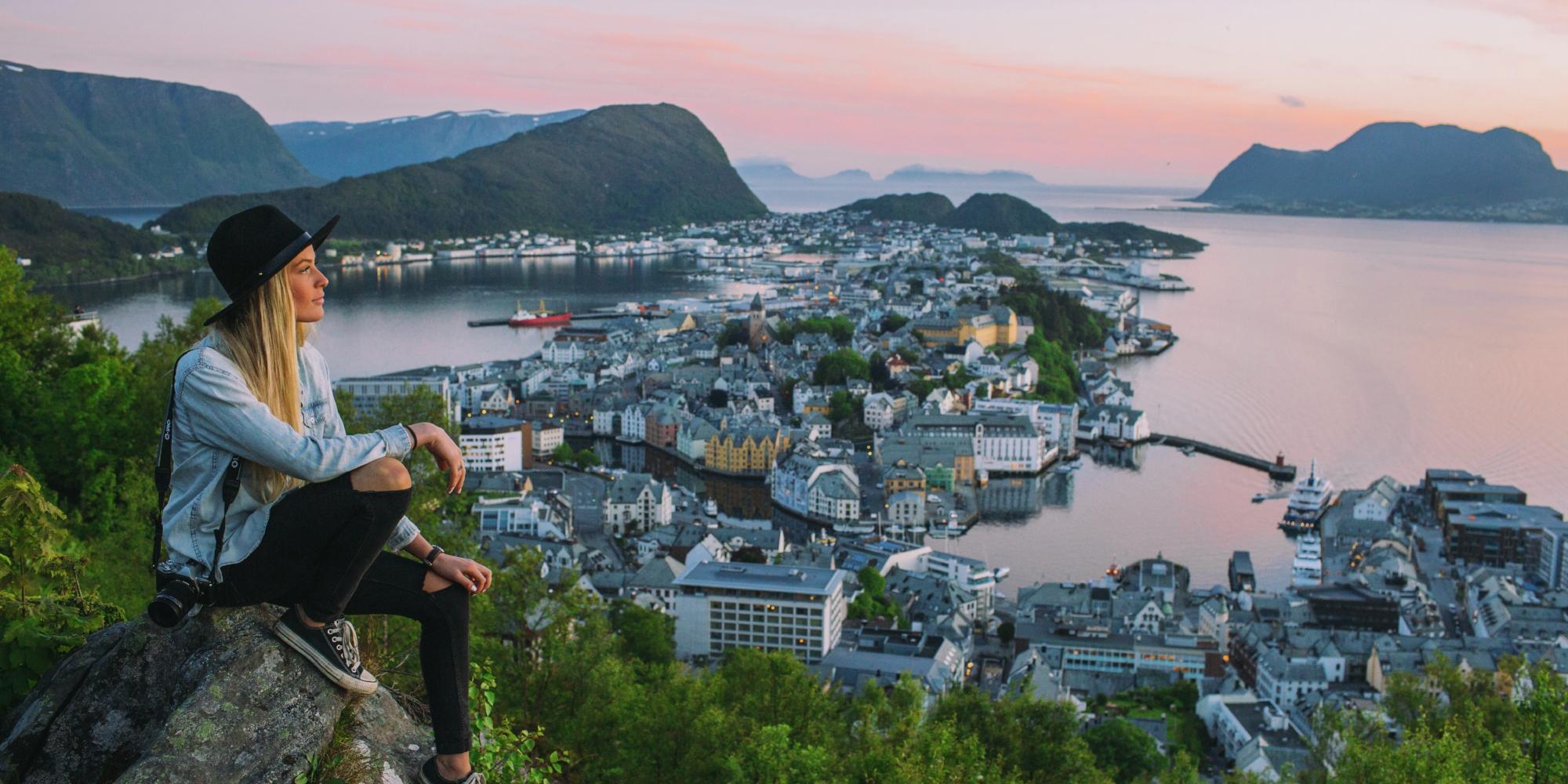 A woman on a city break in Norway is overlooking Ålesund from Aksla viewpoint