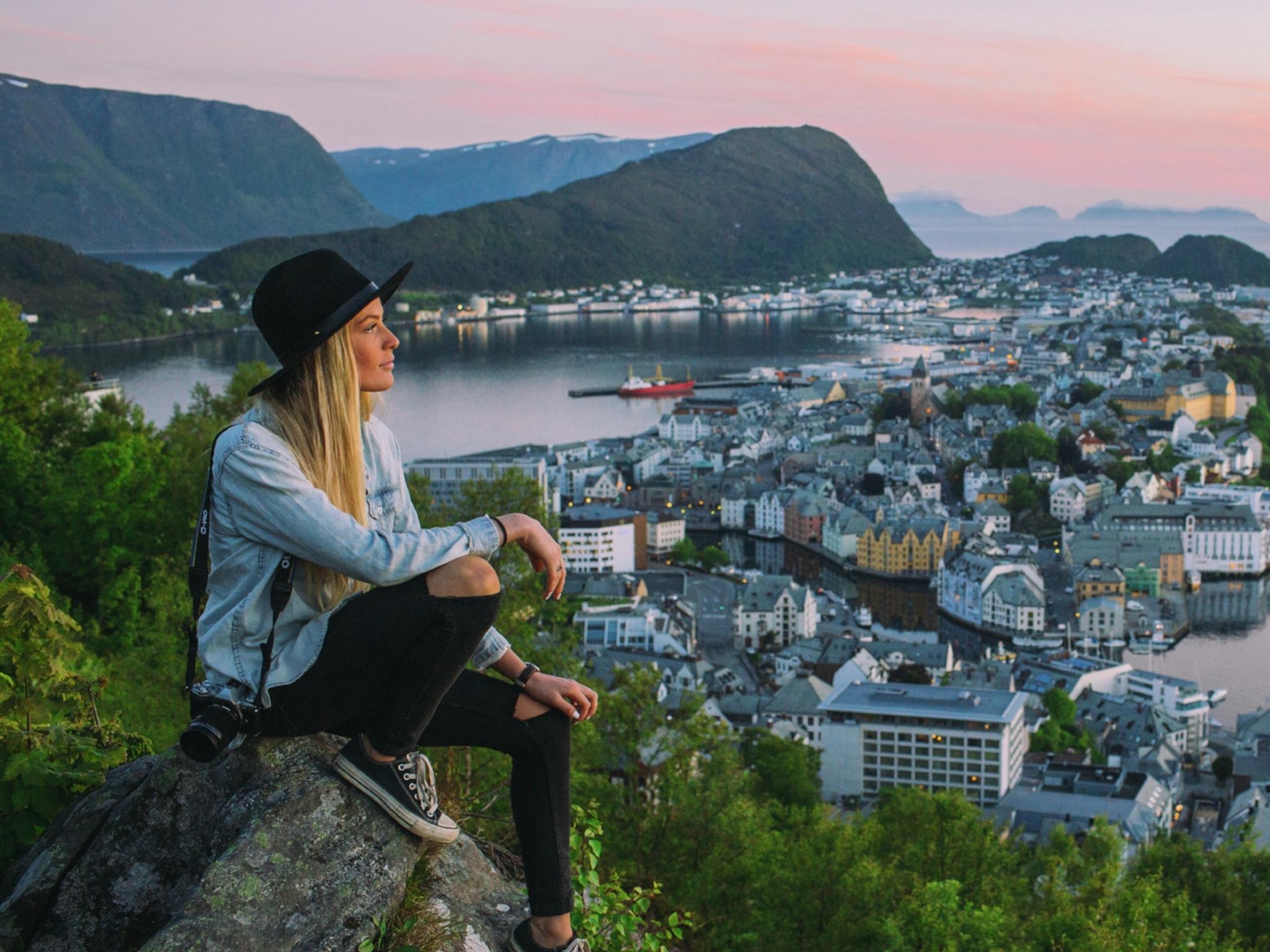 A woman on a city break in Norway is overlooking Ålesund from Aksla viewpoint