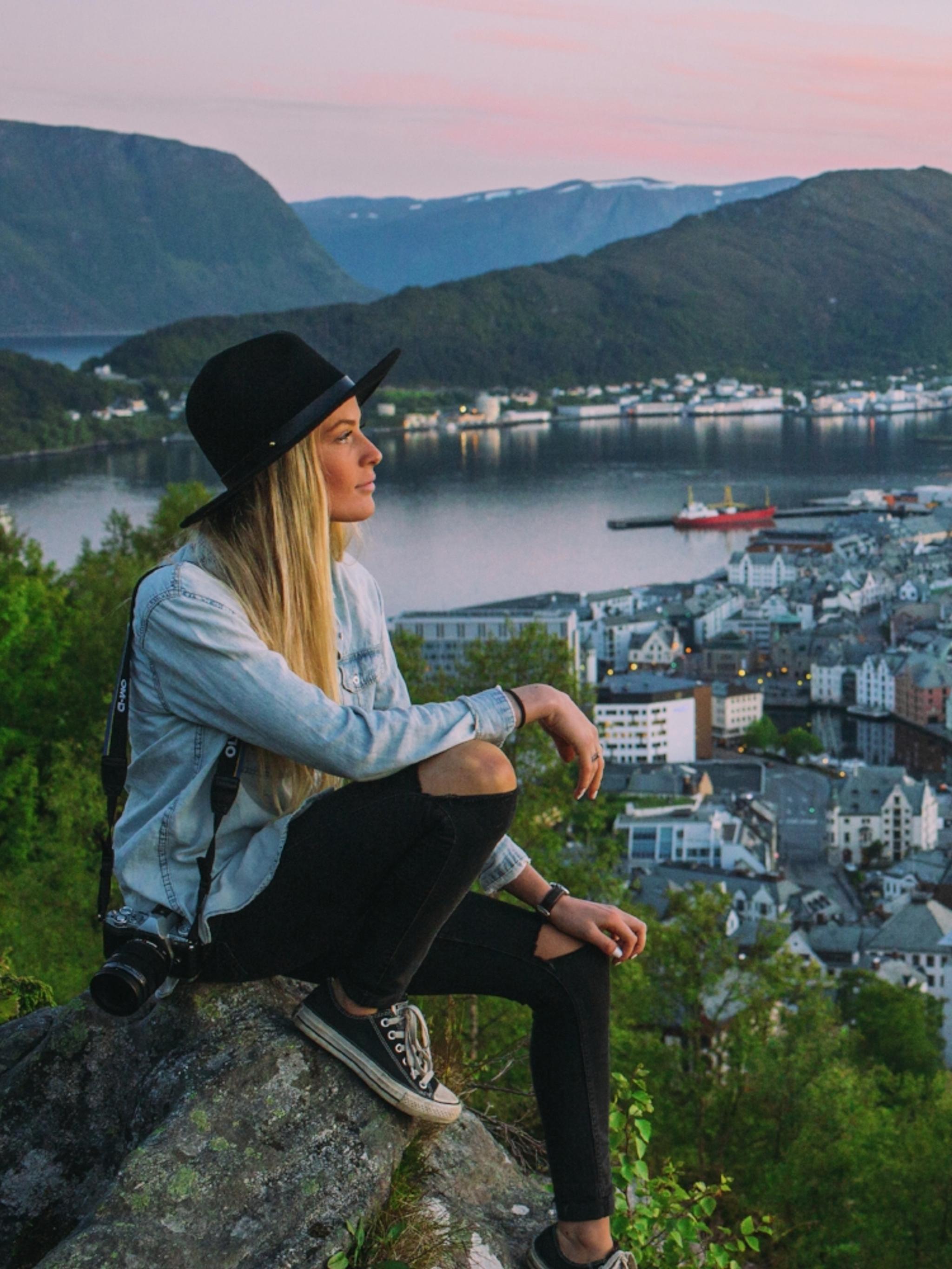 Kortreist byferie: En dame sitter og skuer utover Ålesund fra Aksla utsiktspunkt