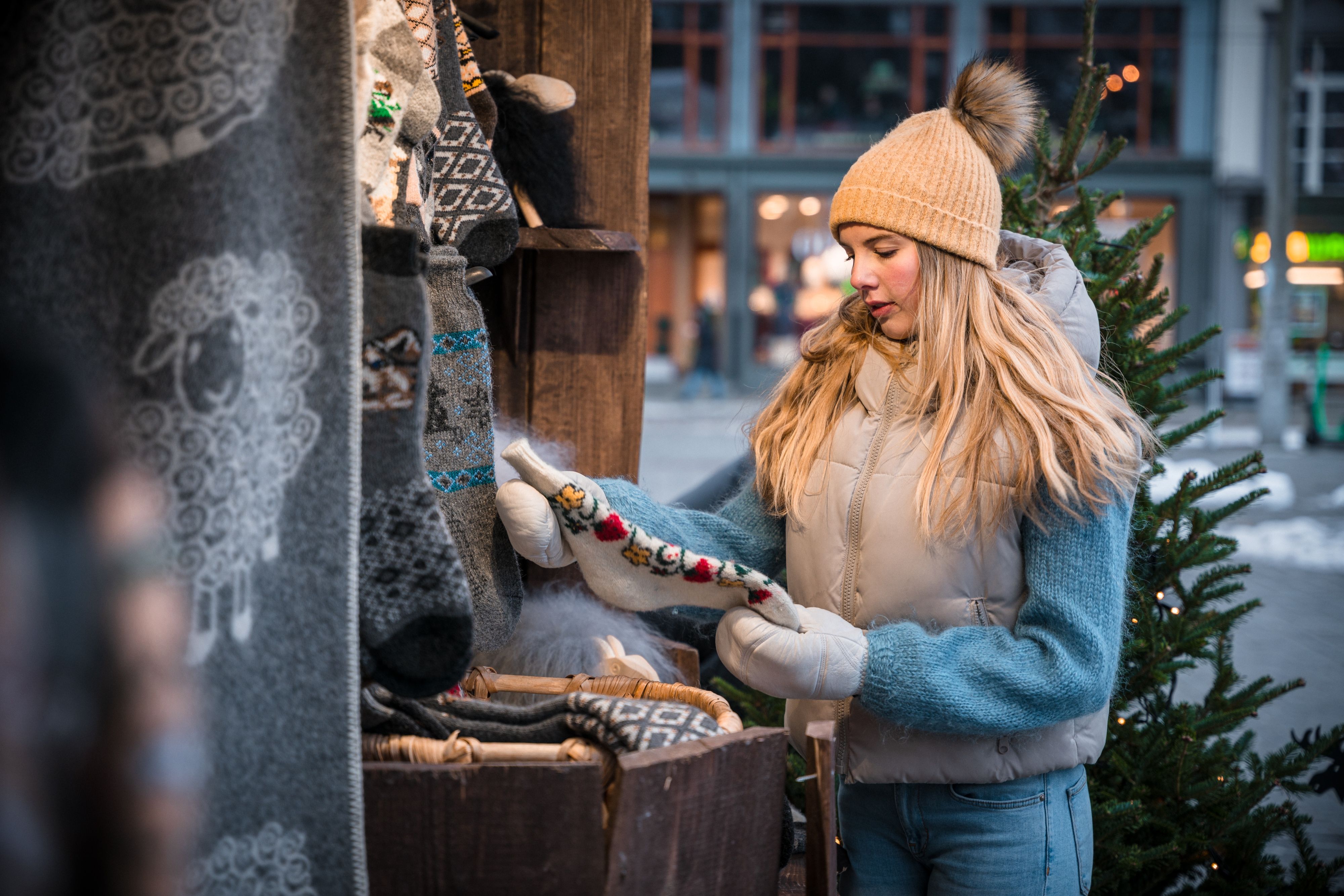 A girl shopping wool items at a Christmas market in Bergen, Fjord Norway