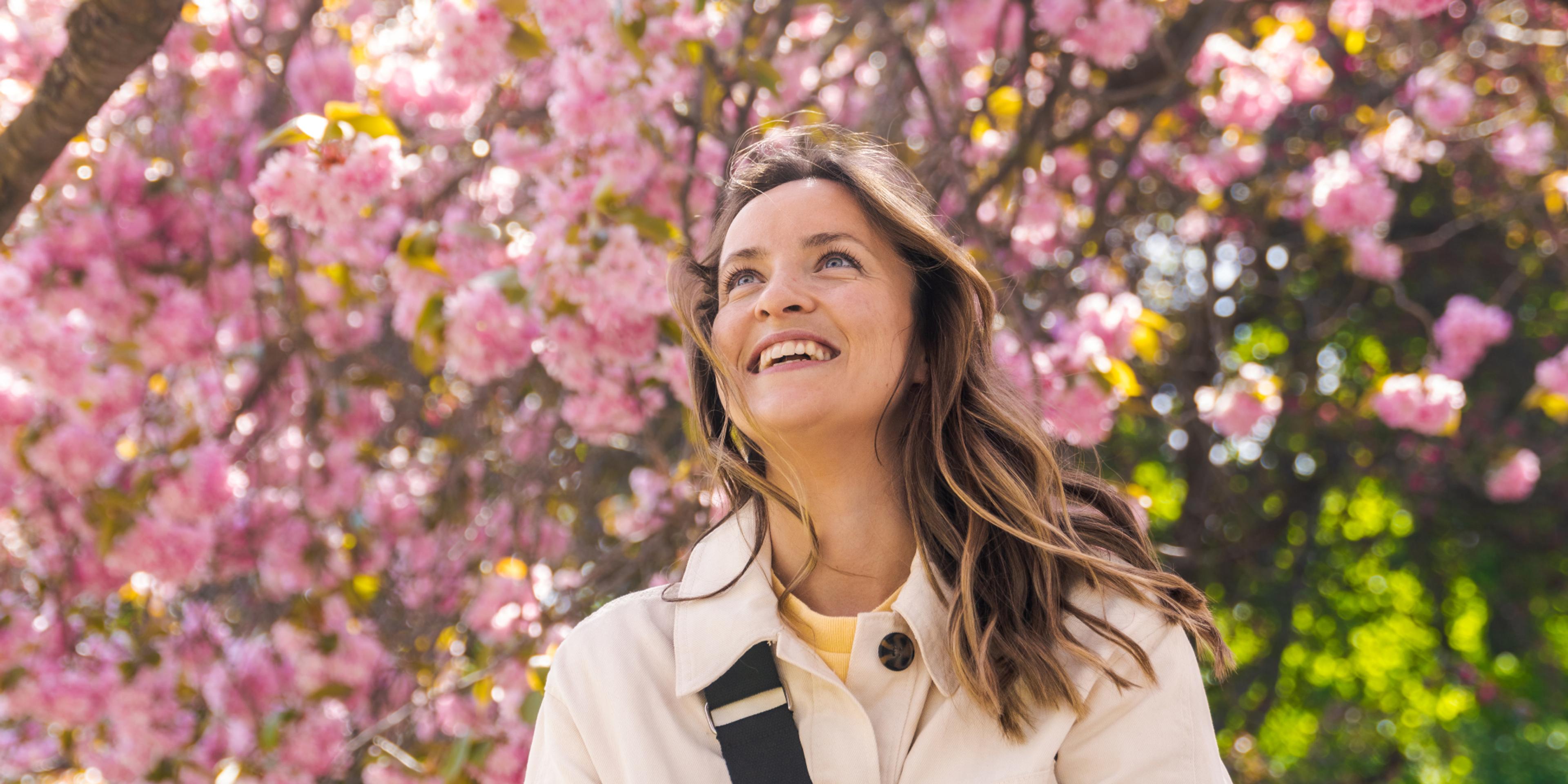 Woman under a pink cherry tree in the Botanic garden at Tøyen in Oslo, Eastern Norway