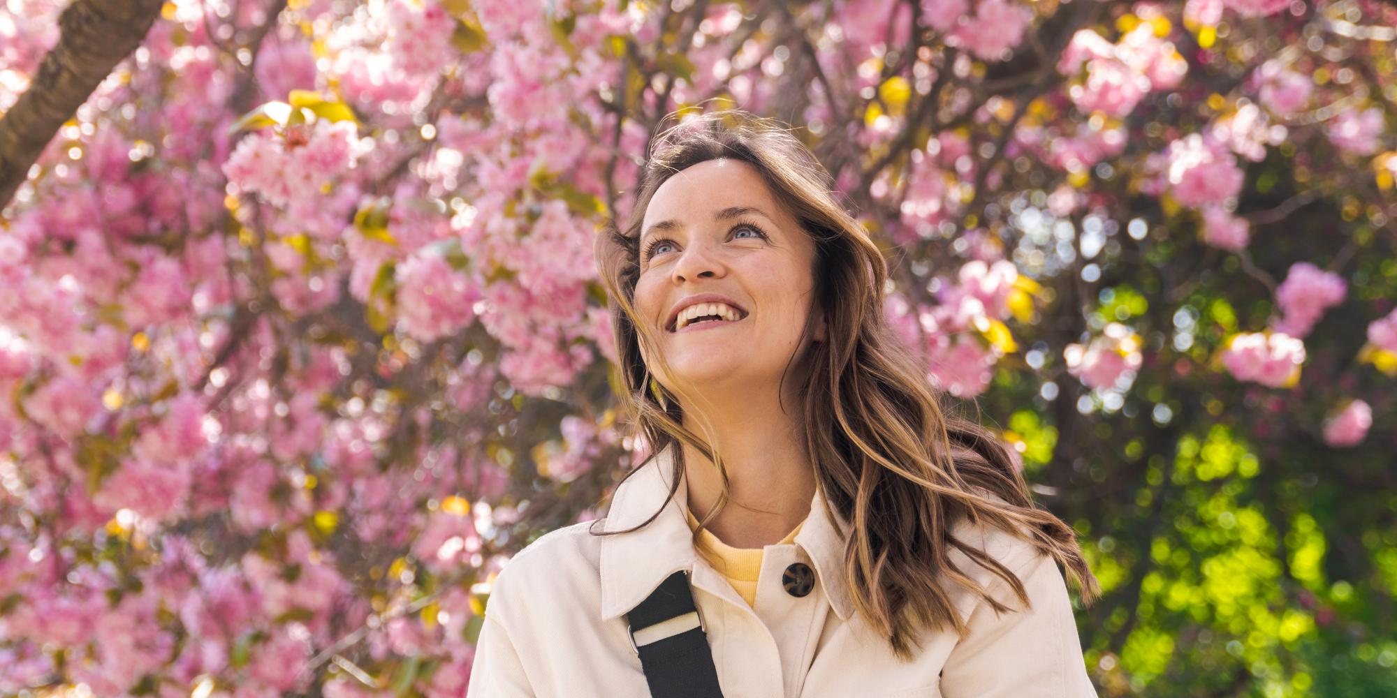 Woman under a pink cherry tree in the Botanic garden at Tøyen in Oslo, Eastern Norway