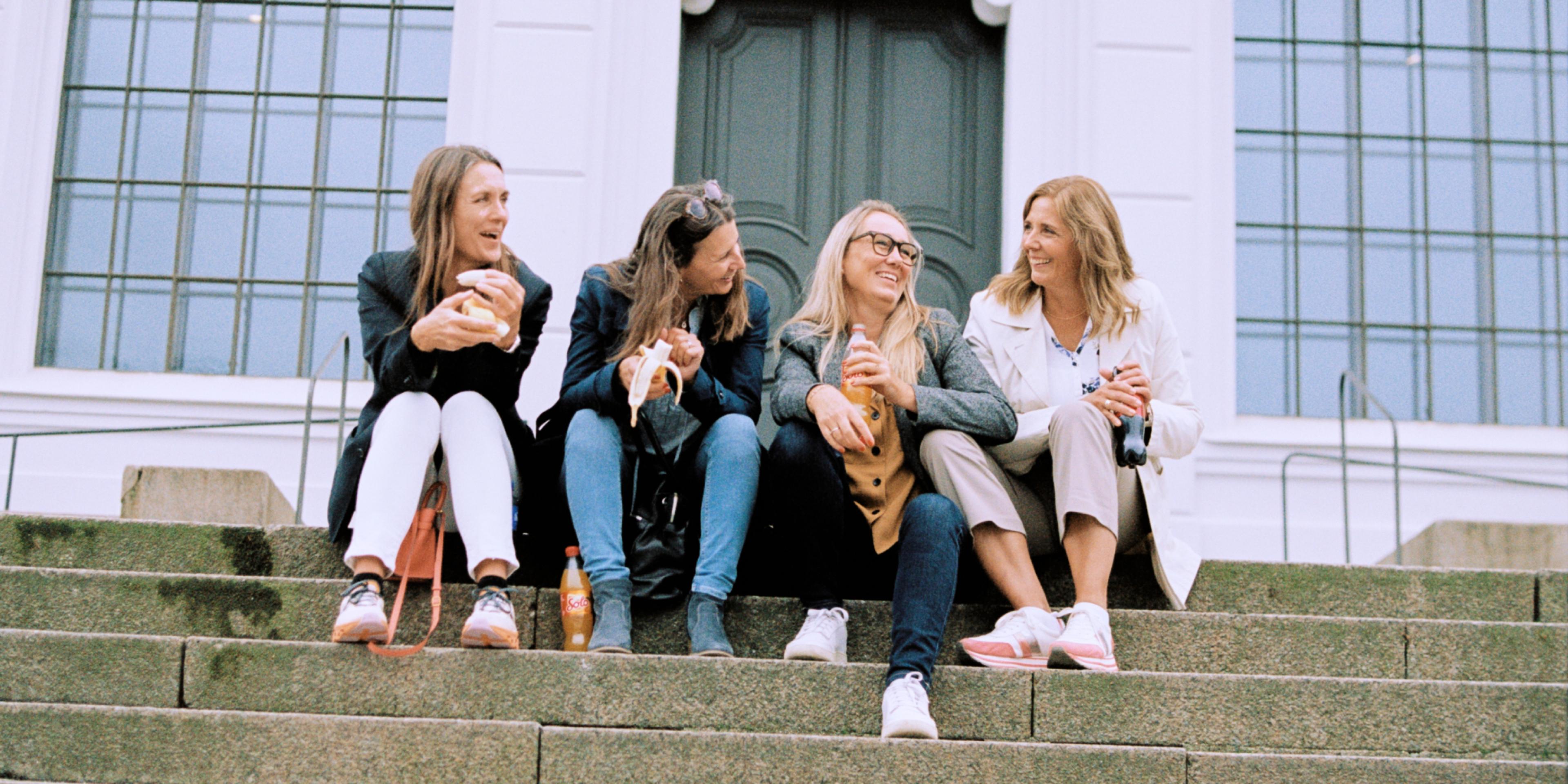 Four women sitting on stairs