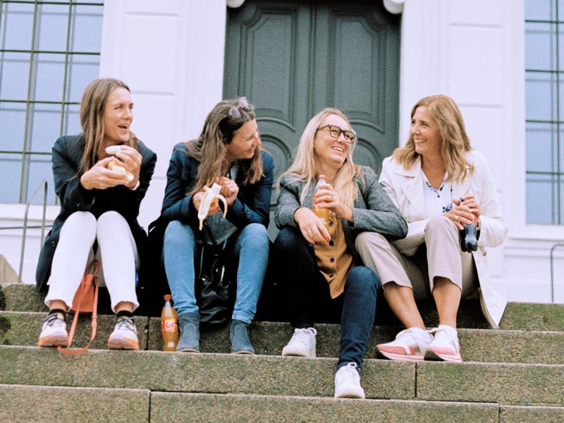 Four women sitting on stairs