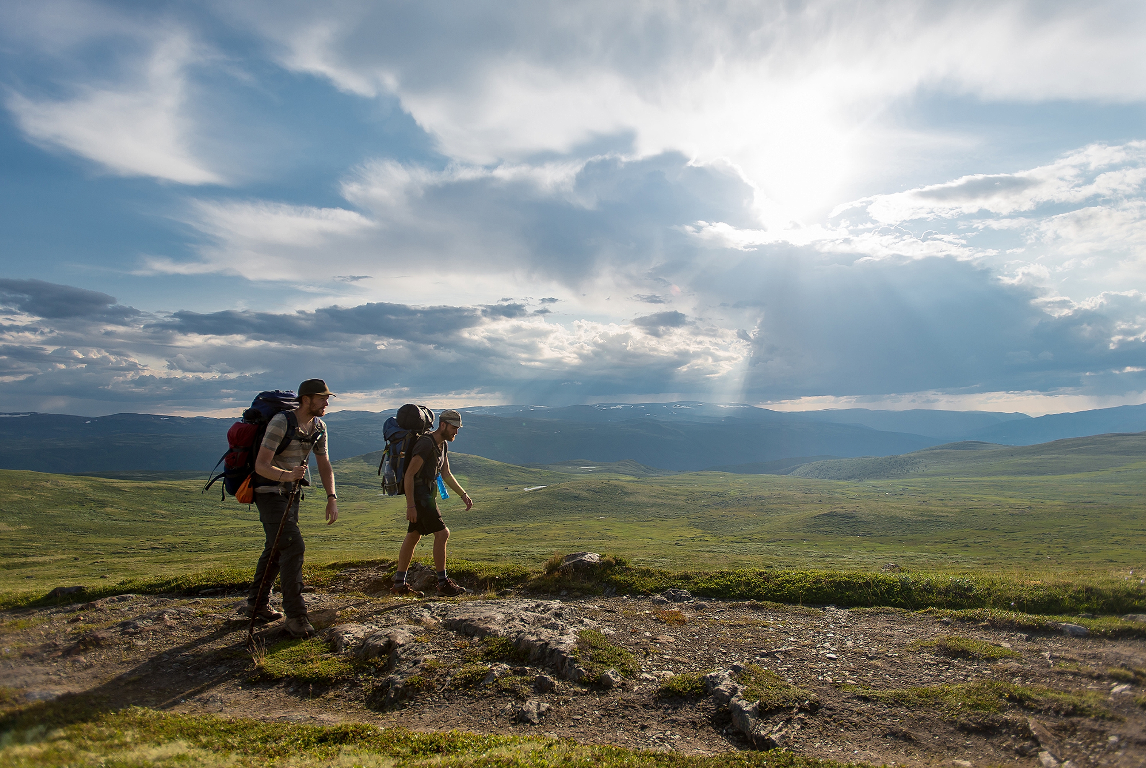 Two men wearing backpacks hiking the Gudbrandsdalen path, the pilgrim trail St. Olav Ways to Trondheim, across Dovrefjell in Eastern Norway