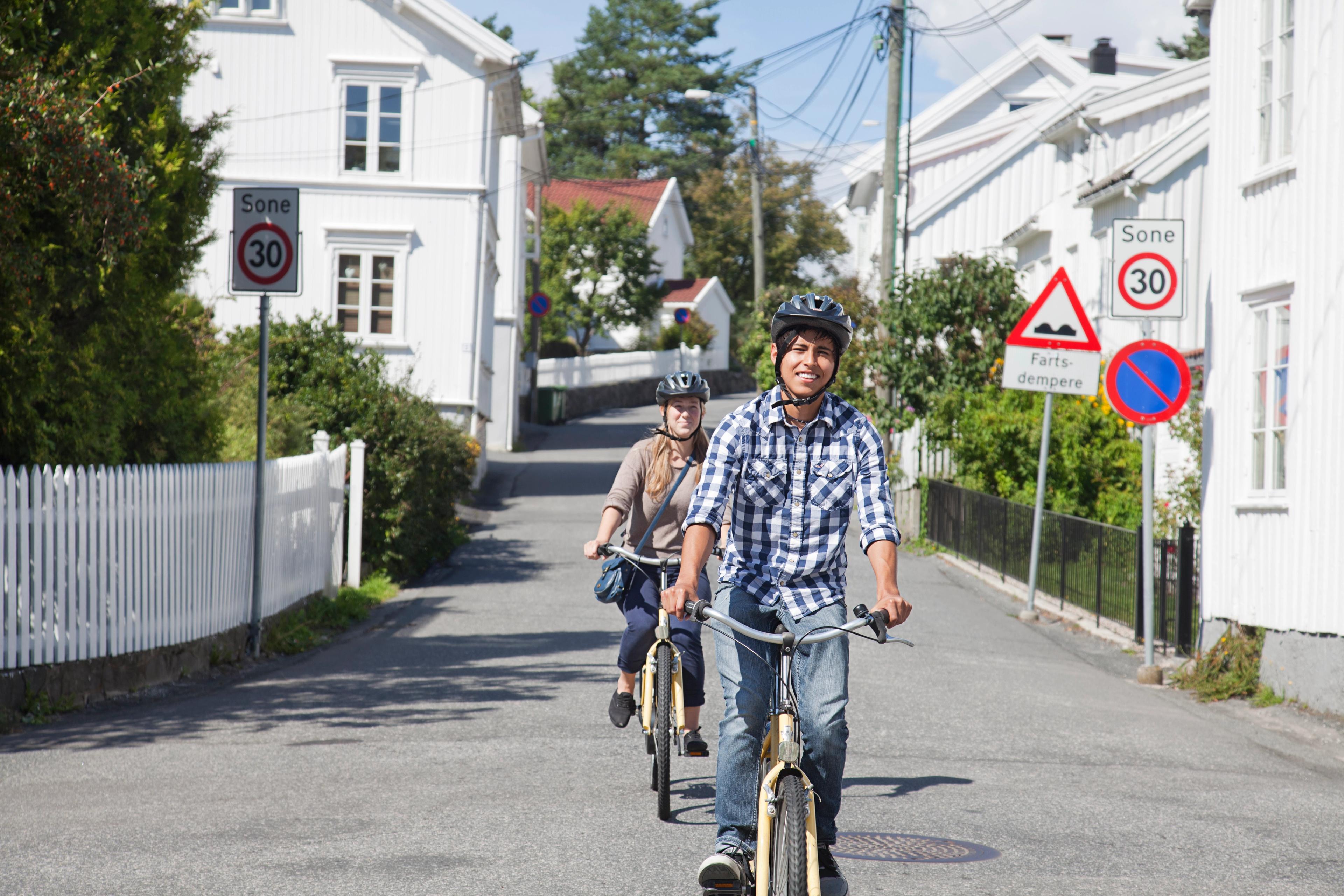 Due persone in bicicletta su una strada di Grimstad, Norvegia meridionale