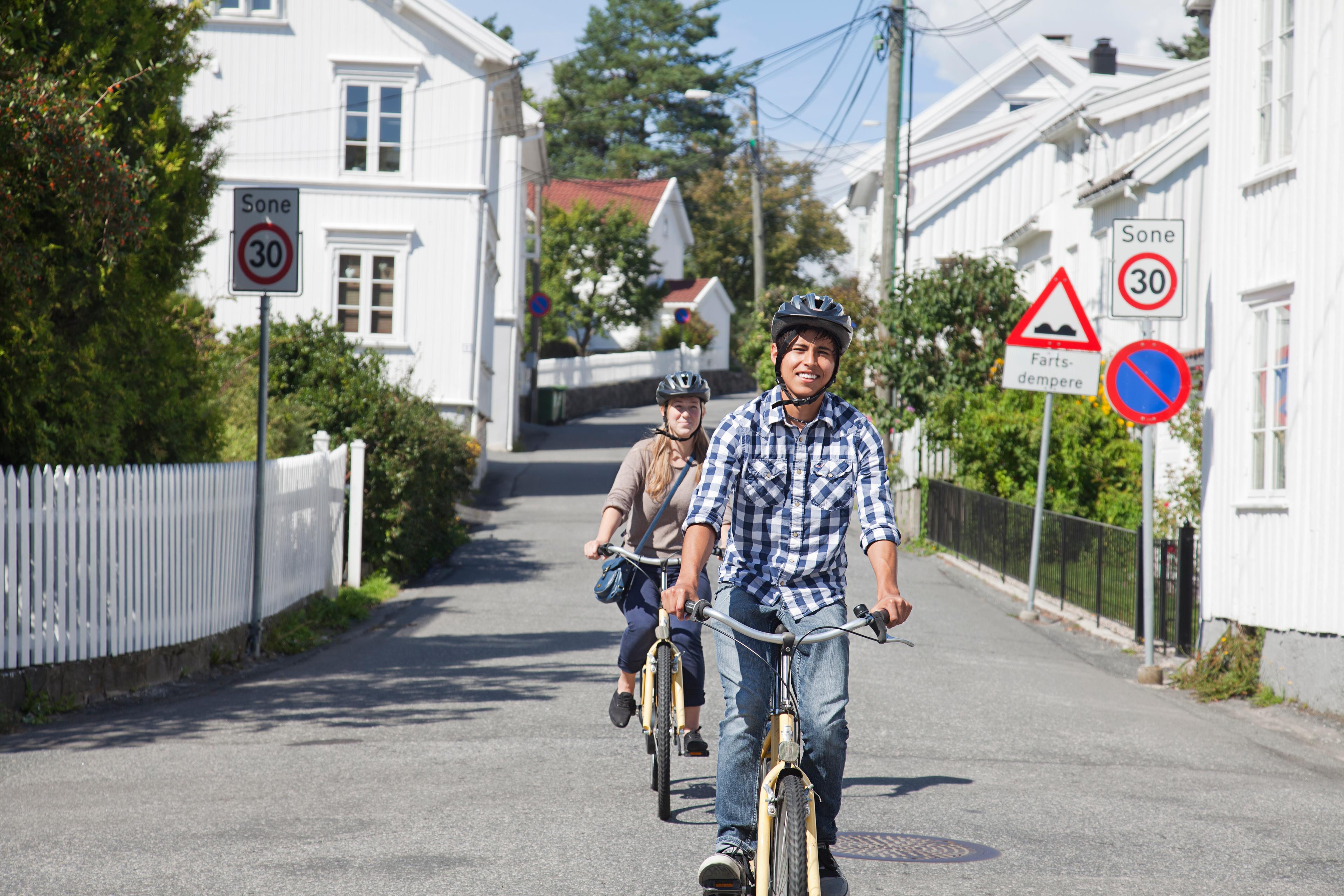 Due persone in bicicletta su una strada di Grimstad, Norvegia meridionale
