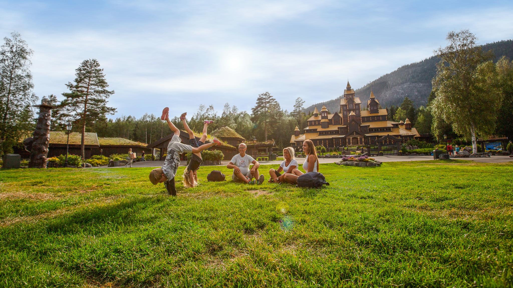 A family is having fun in front of the Fairy Tale Castle in Hunderfossen Adventure Park, Lillehammer