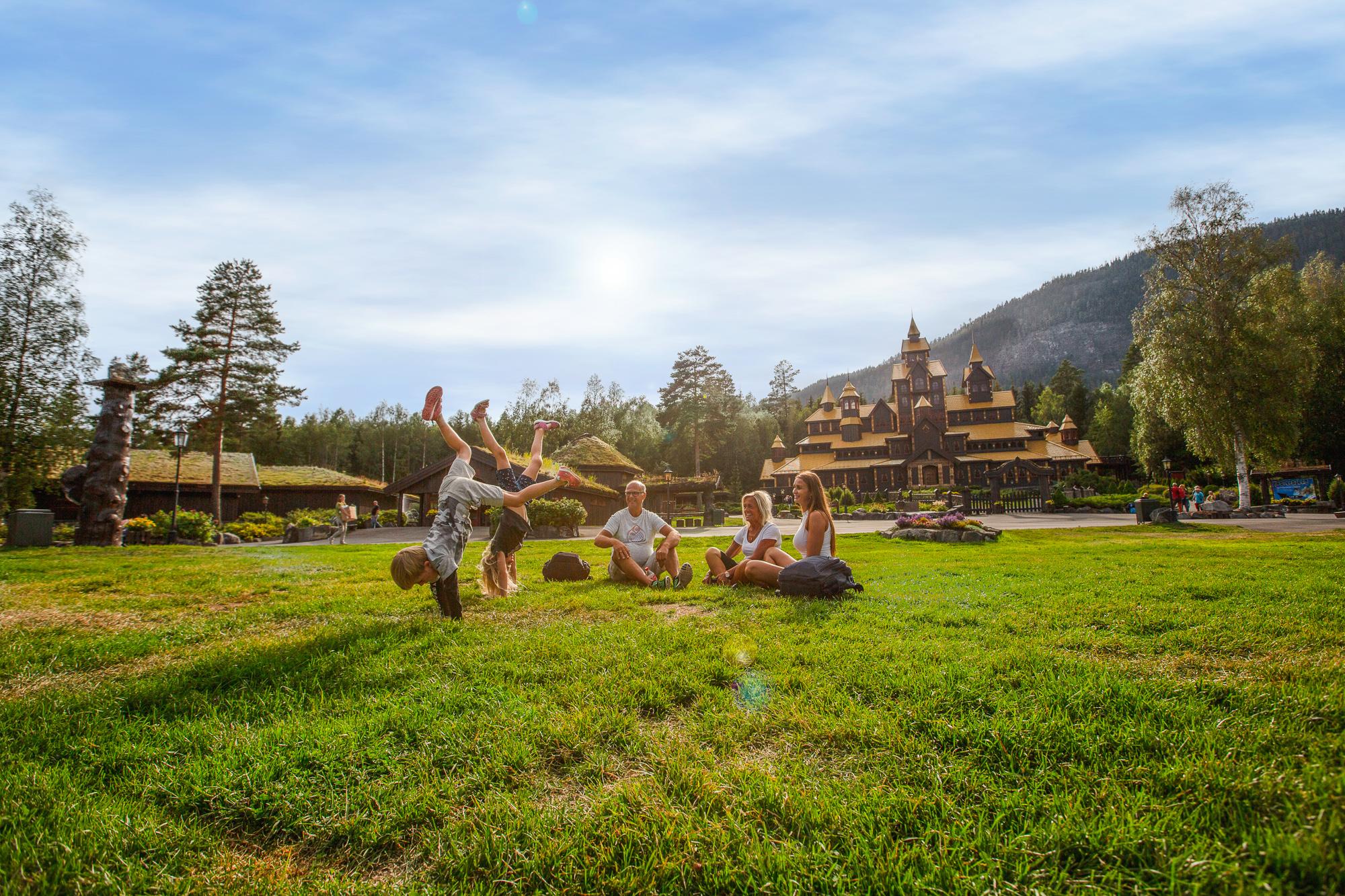 A family is having fun in front of the Fairy Tale Castle in Hunderfossen Adventure Park, Lillehammer
