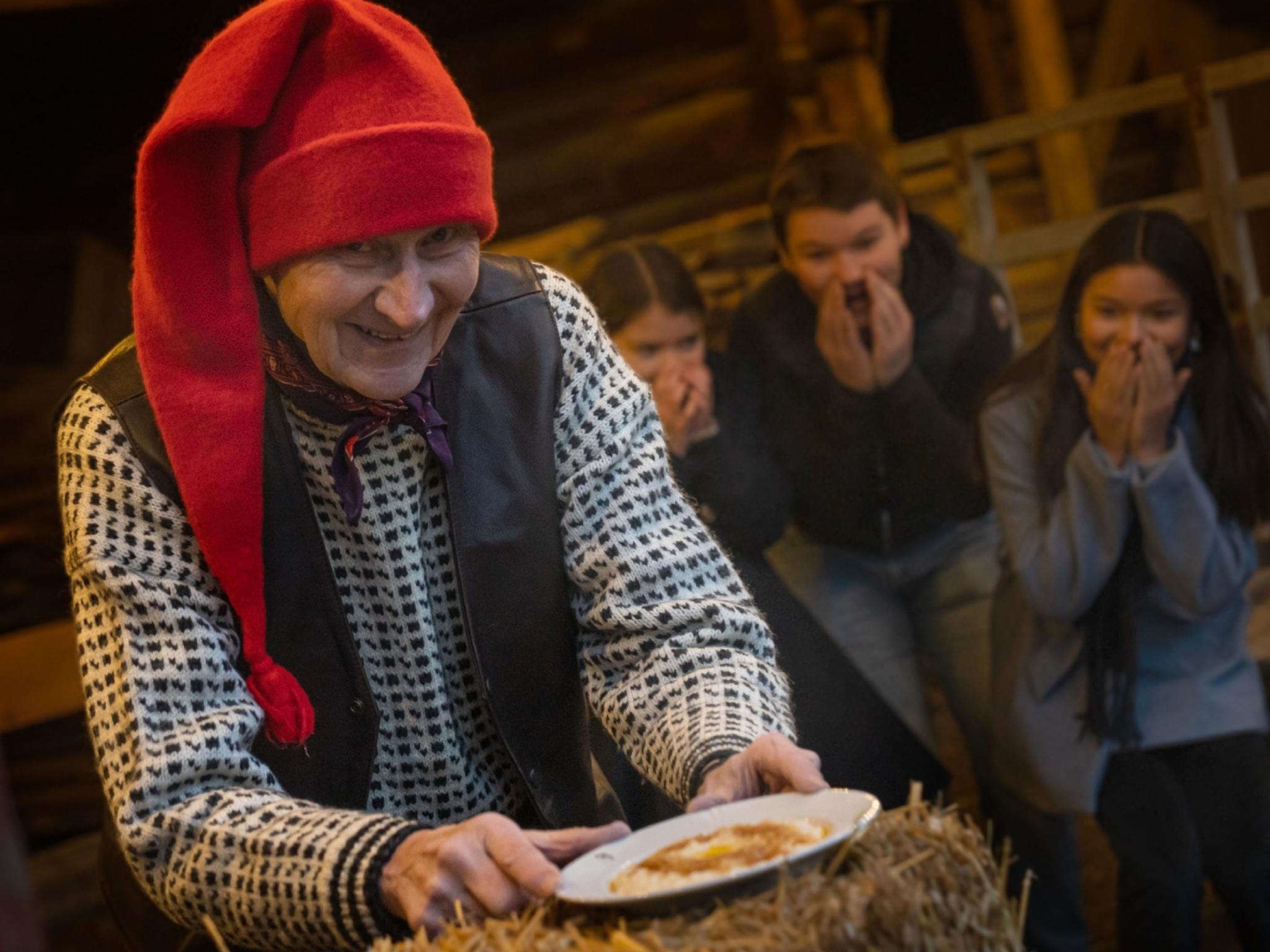 The Norwegian Santa is getting a hold of the porridge, while children is excited in the background at Bygdøy, Eastern Norway