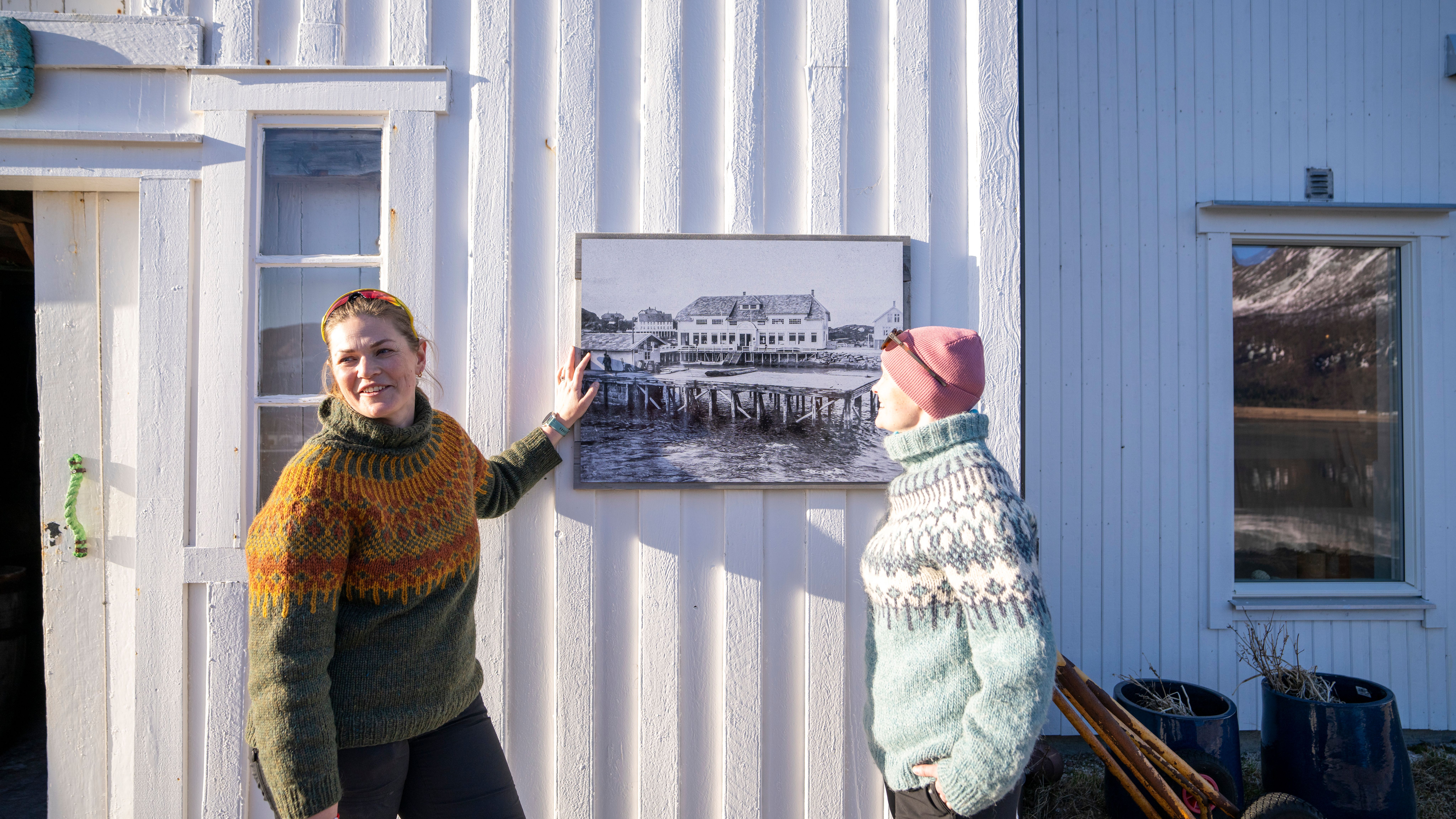 Two women in front of a white wooden house