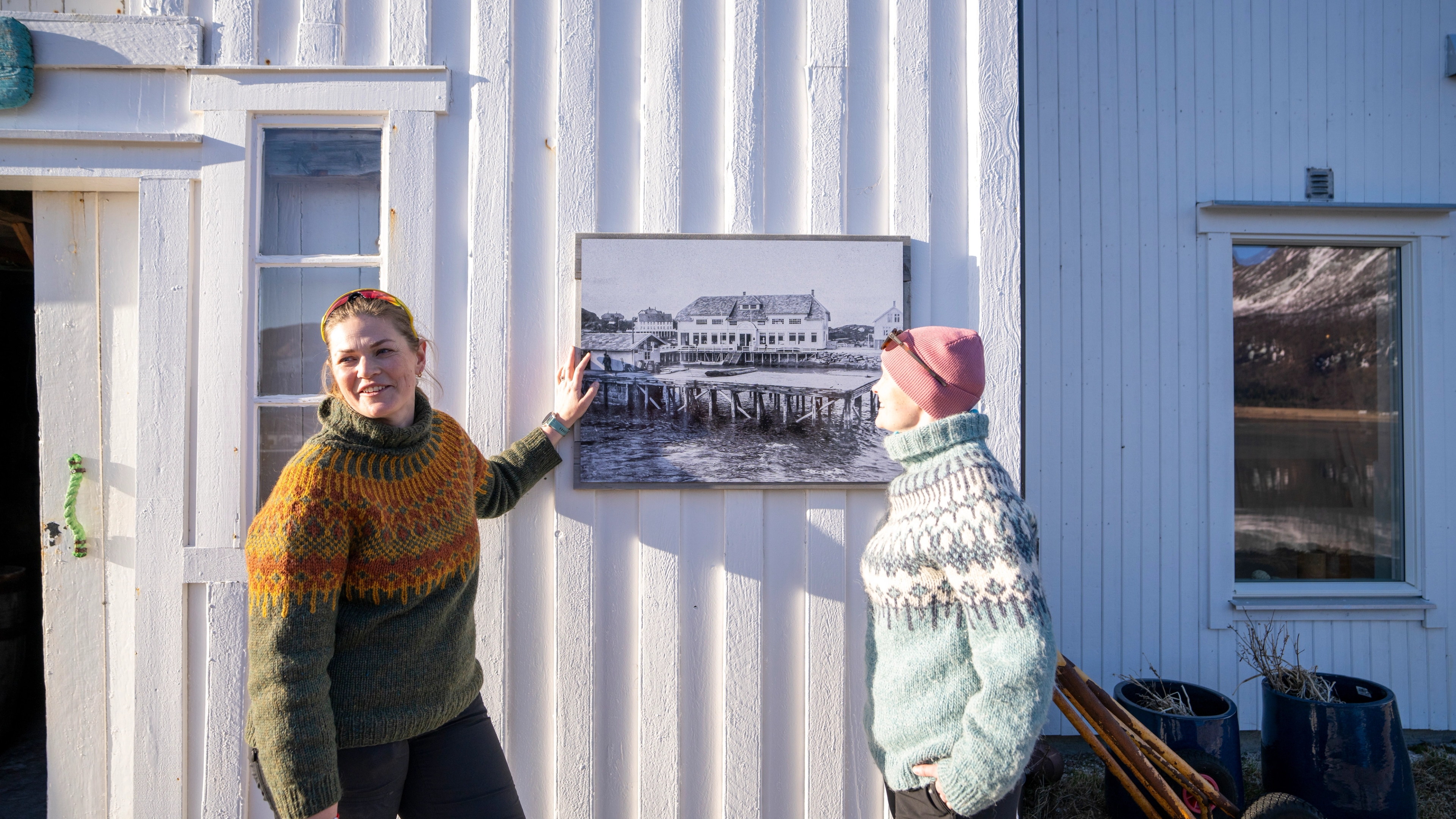 Two women in front of a white wooden house