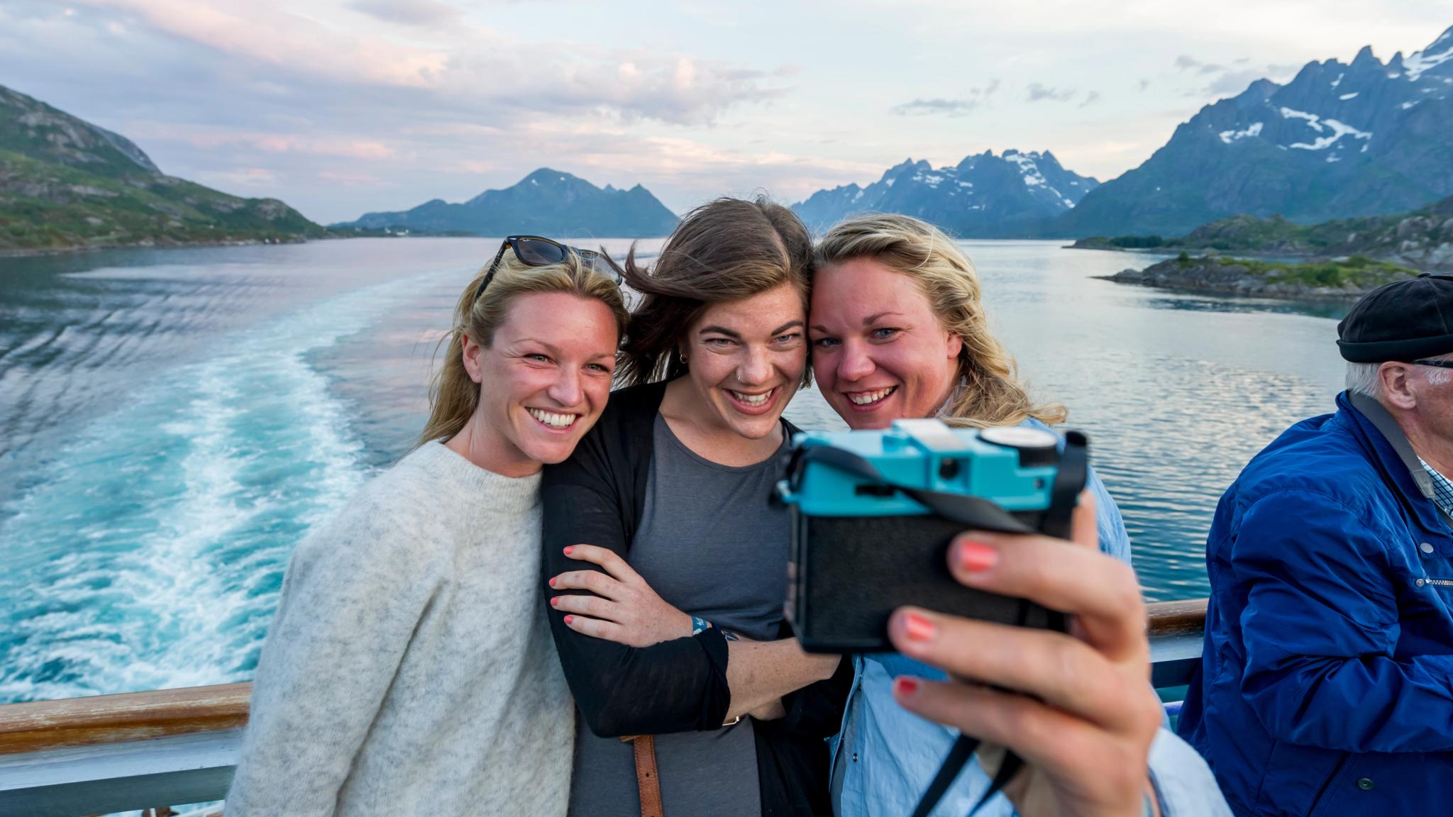 Three people taking a selfie on on a Hurtigruten ship in Norway