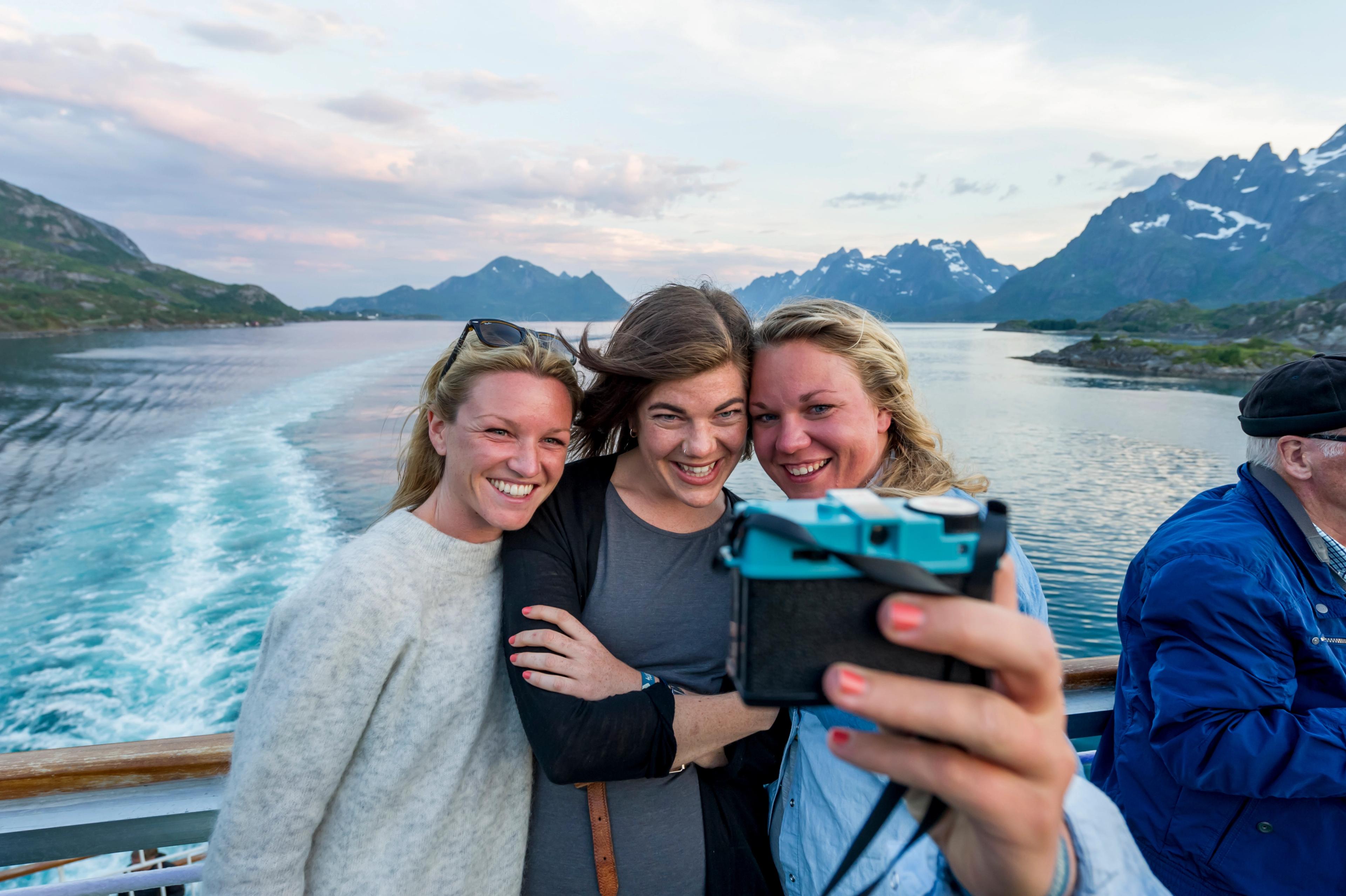 Three people taking a selfie on on a Hurtigruten ship in Norway