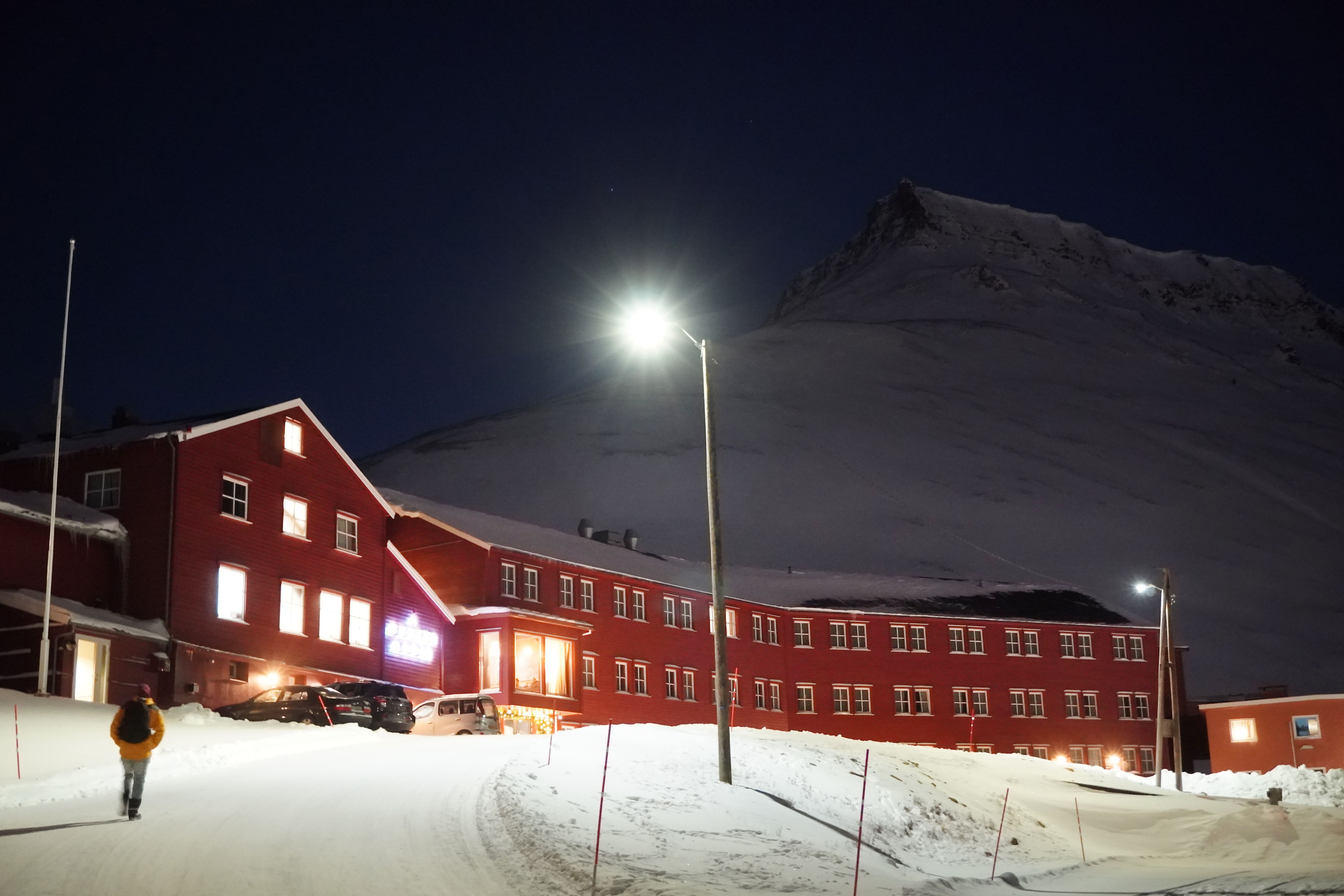 A red house in front of a mountain