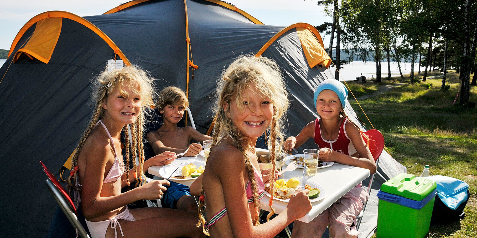 Children eating outside a camping tent on Hamre famliecamping in Kristiansand, Southern Norway