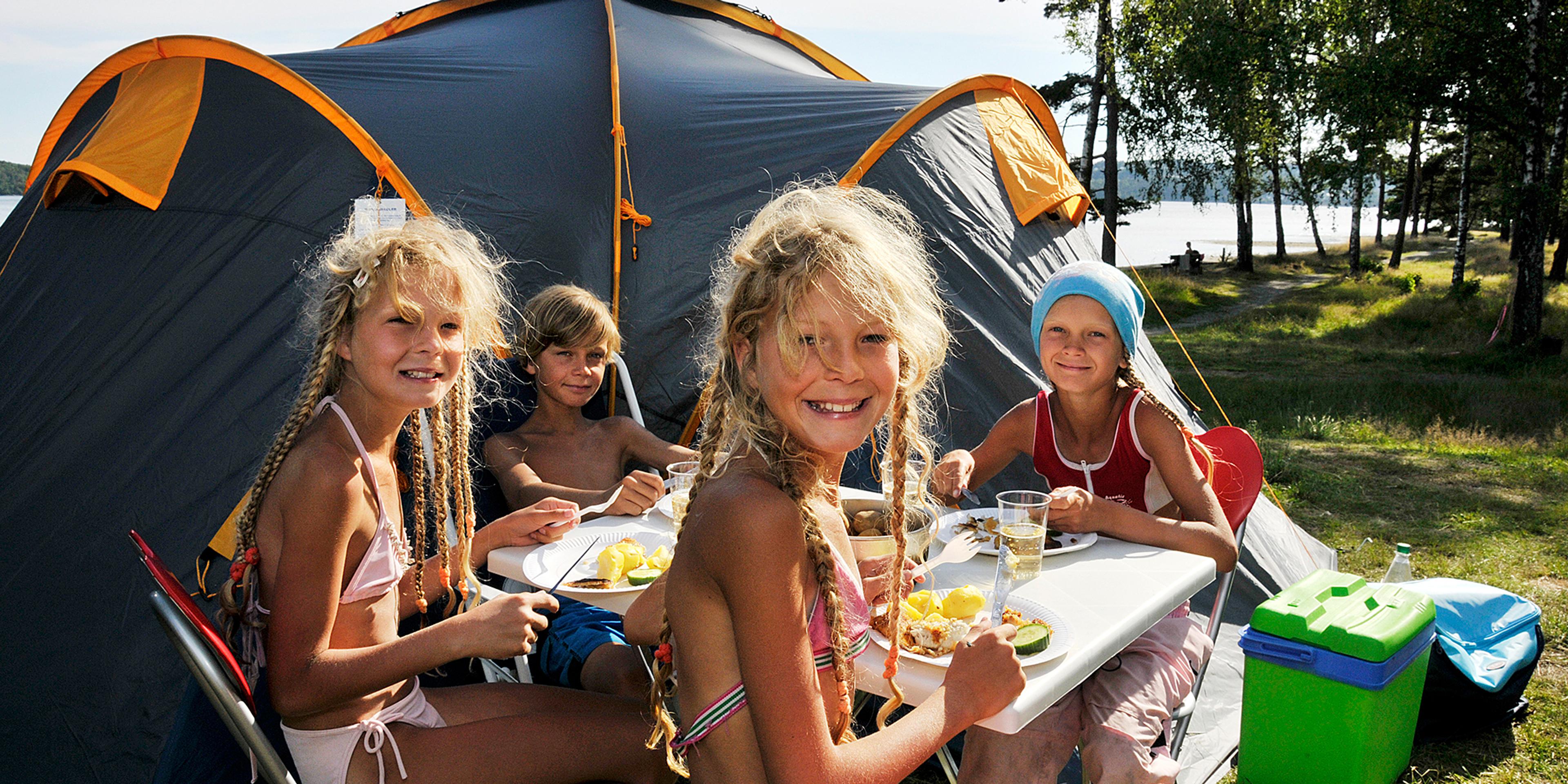 Children eating outside a camping tent on Hamre famliecamping in Kristiansand, Southern Norway