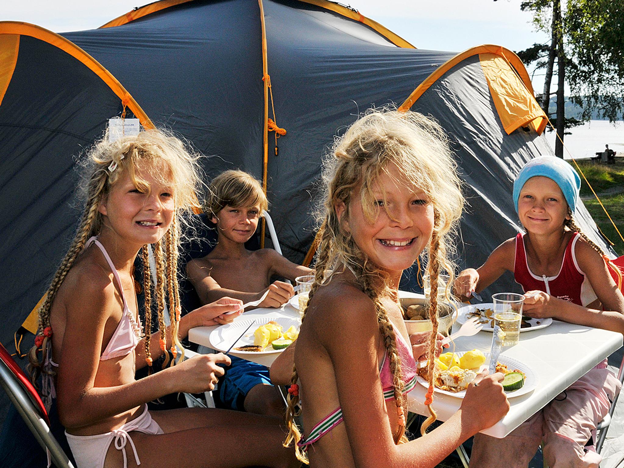 Children eating outside a camping tent on Hamre famliecamping in Kristiansand, Southern Norway