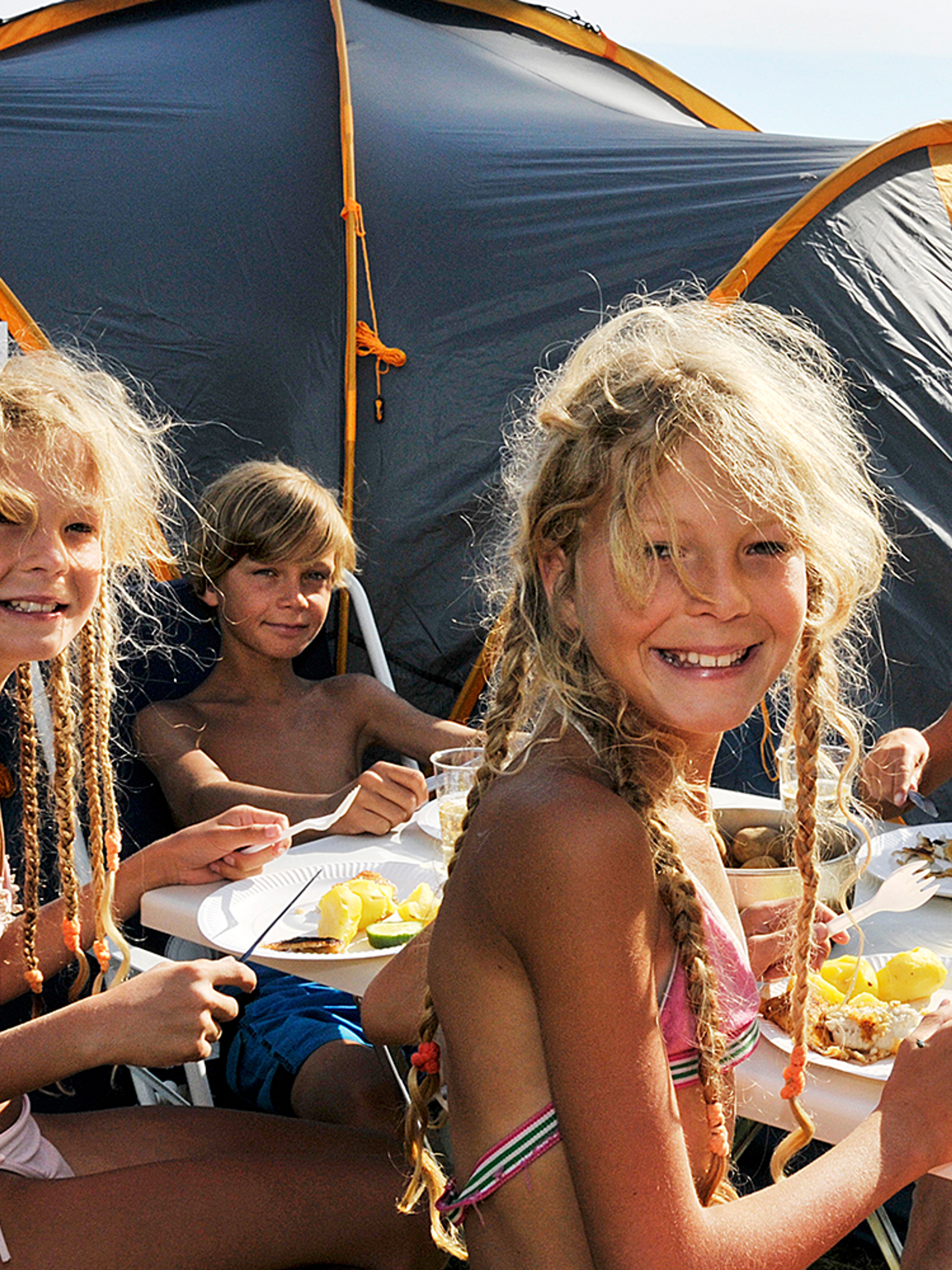 Children eating outside a camping tent on Hamre famliecamping in Kristiansand, Southern Norway