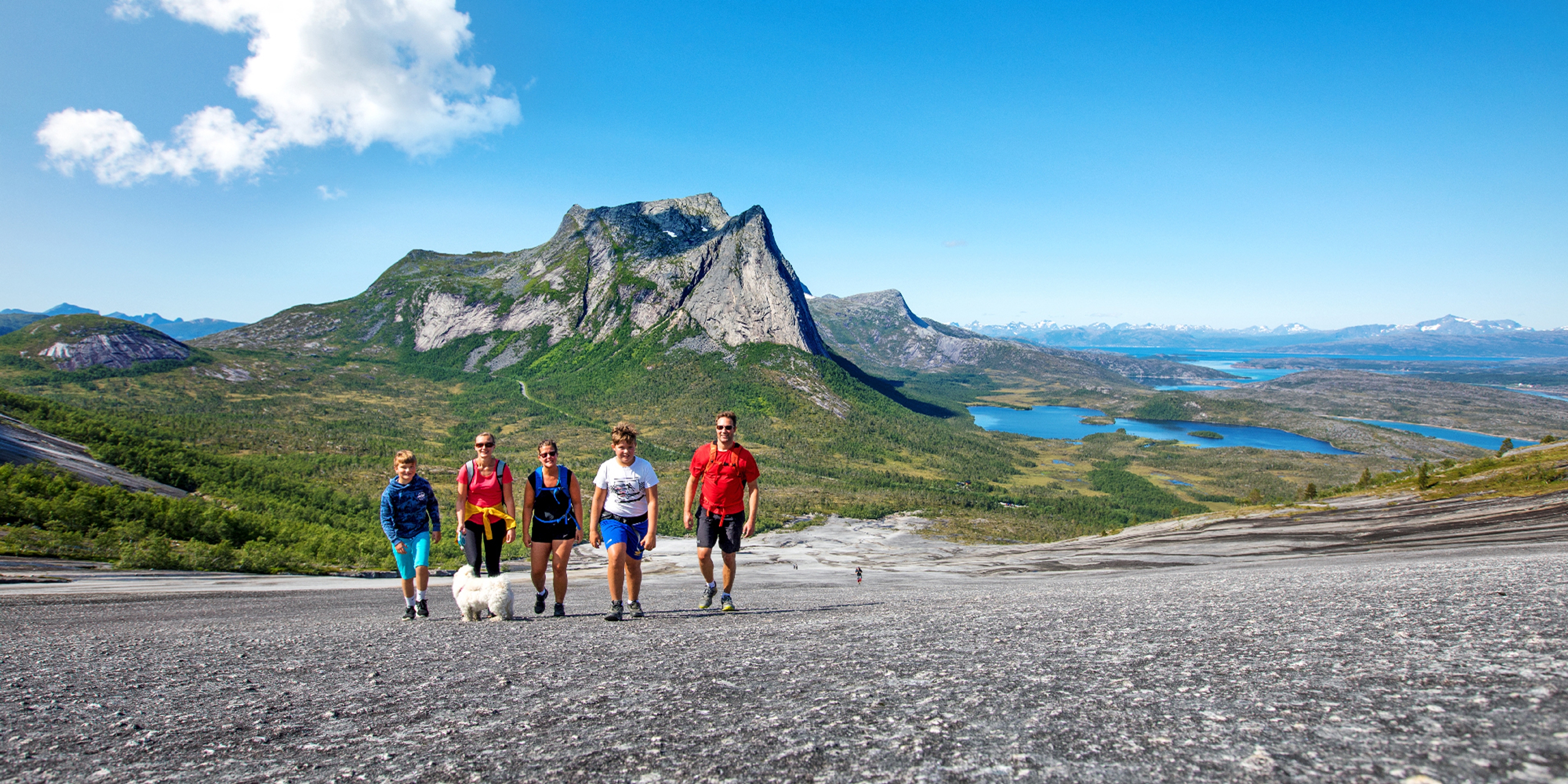 Eine Familie wandert auf dem Hügel Verdenssvaet am Efjord in Narvik, Nordnorwegen