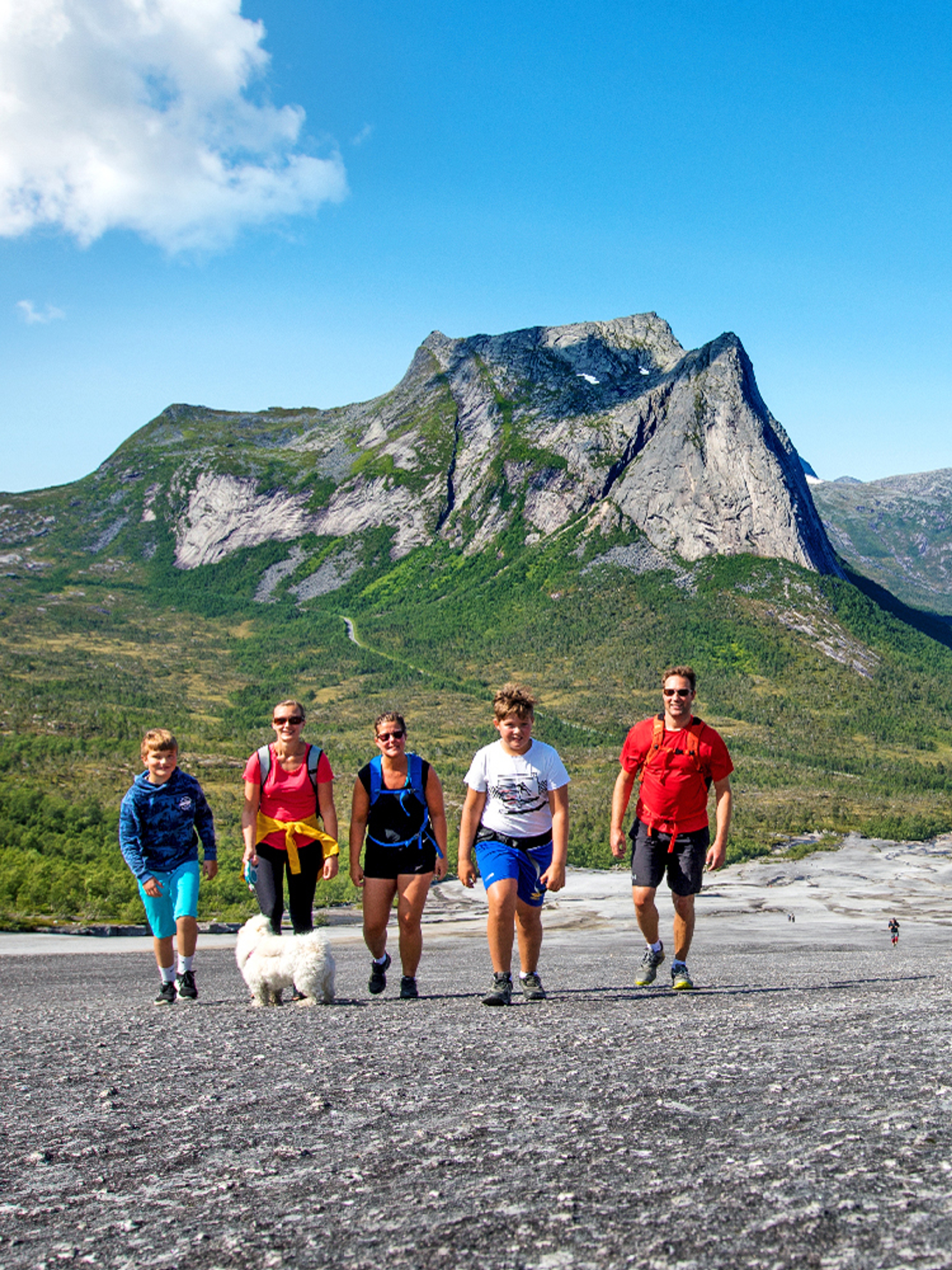 A family is hiking the Verdenssvaet hill by Efjorden in Narvik, Northern Norway