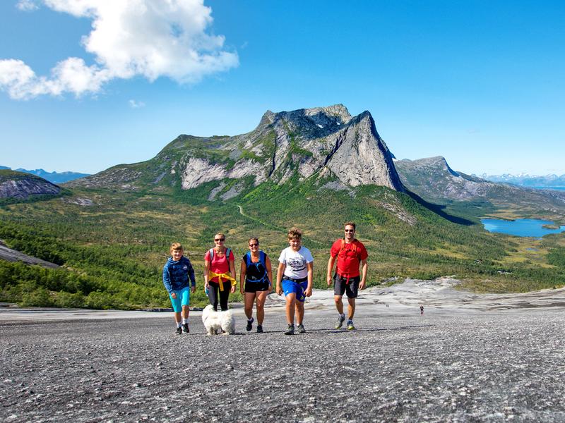 Una familia hace senderismo por la colina de Verdenssvaet, Narvik, en el Norte de Noruega.
